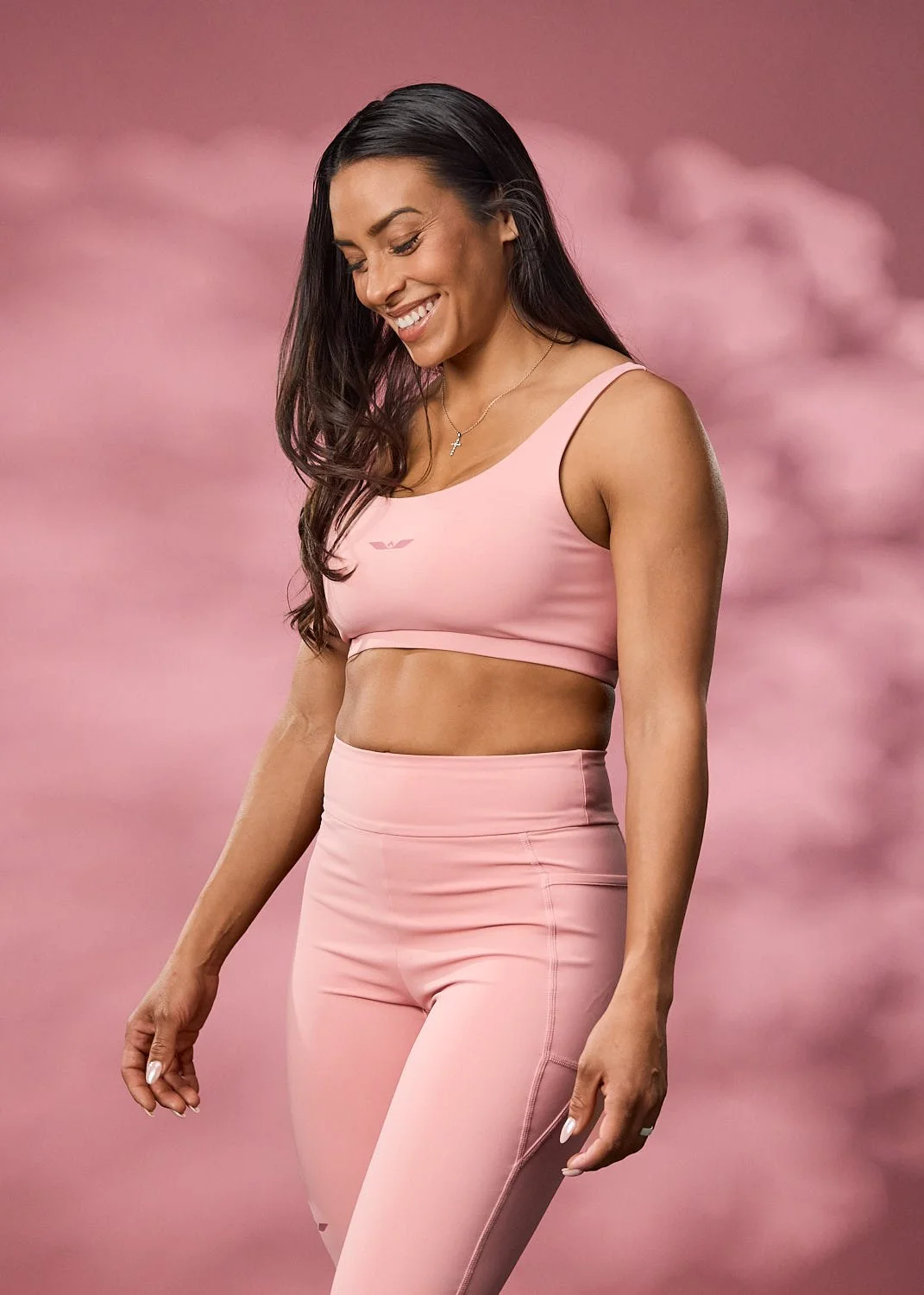 Women's pink sports bra, photographed with clean studio lighting with pink backdrop