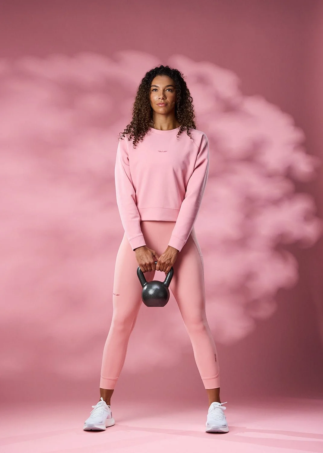 Women's pink athletic clothing on pink backdrop in clean studio lighting