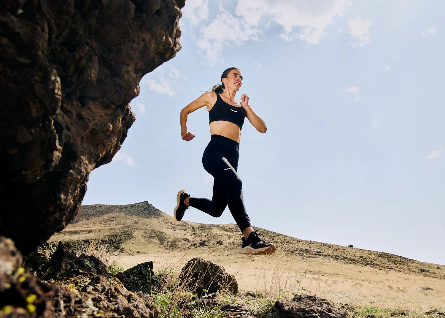 Commercial lifestyle shot of athlete running in sportswear and jumping in Flagstaff daylight
