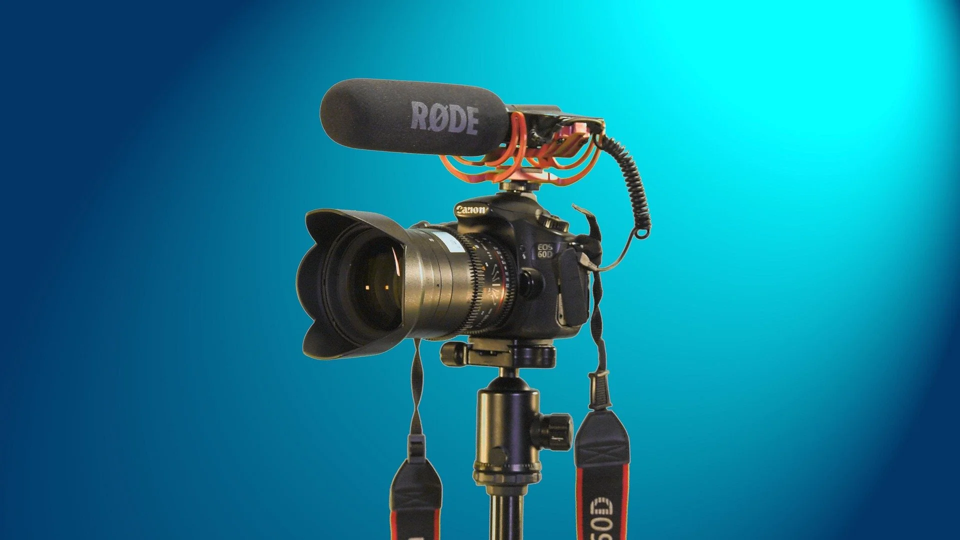 A professional video camera with a microphone mounted on top against a gradient blue background.