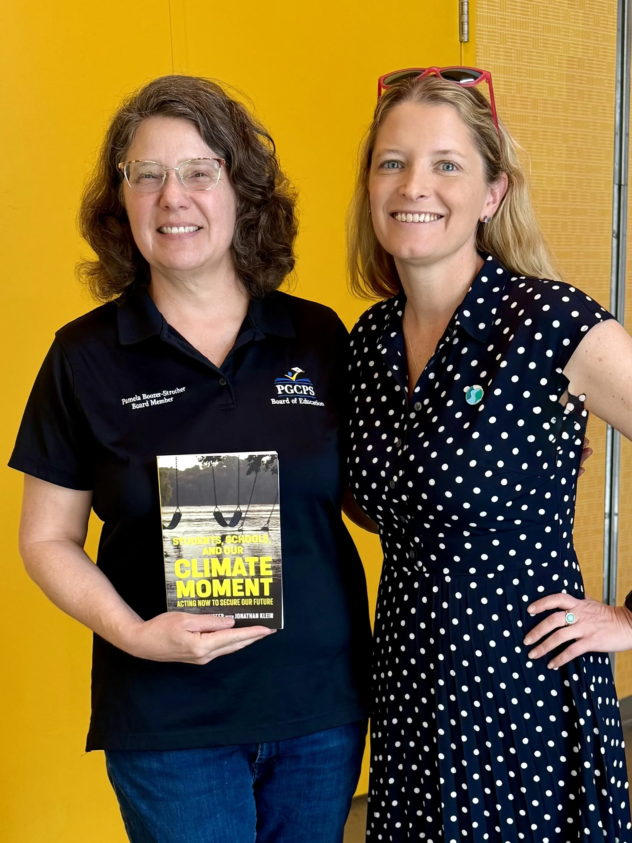 Laura with school board member holding book