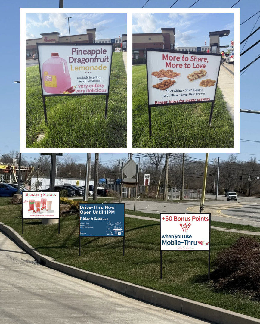 Multiple signs outdoors advertising various products and services, including pineapple dragonfruit lemonade, chicken wings, chicken strips, chicken nuggets, and chicken minis; promoting drive-thru service, bonus points with mobile ordering, and a strawberry hibiscus drink.