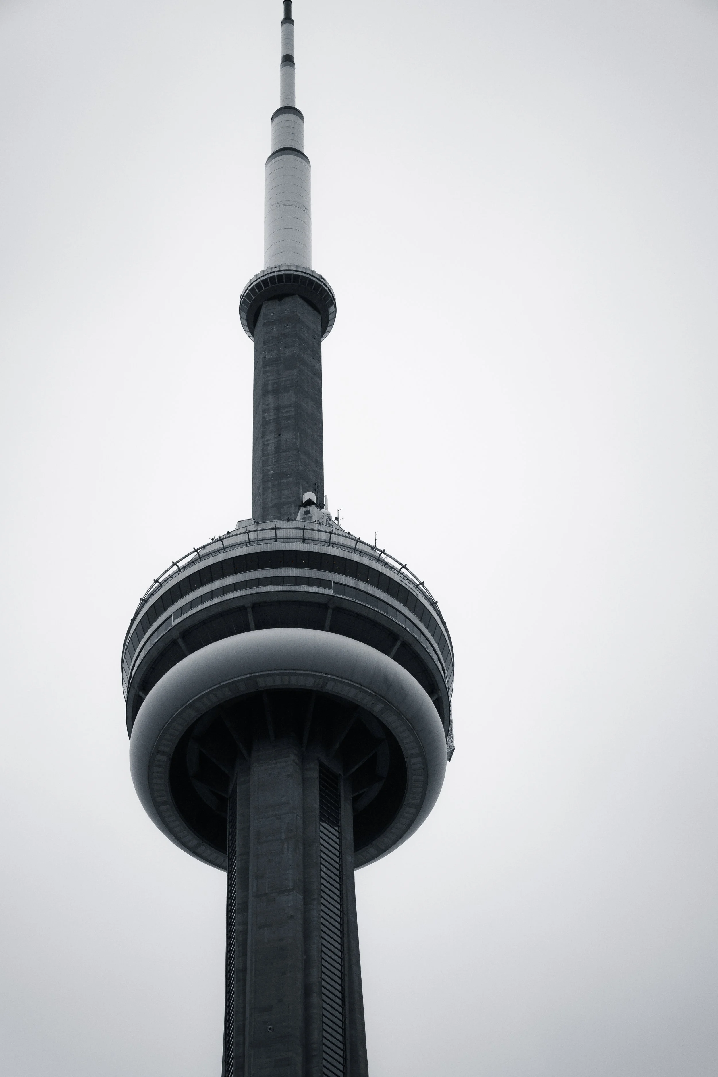 A tall television or observation tower with a large circular platform near the top, set against a cloudy sky.