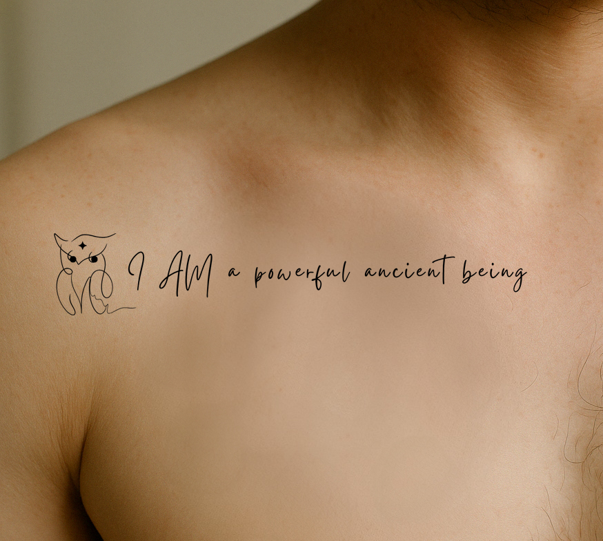 A male has a tattoo on the right upper chest that reads: I am a powerful ancient being. Next to it there's an owl with a 4 pointed star in the forehead. 