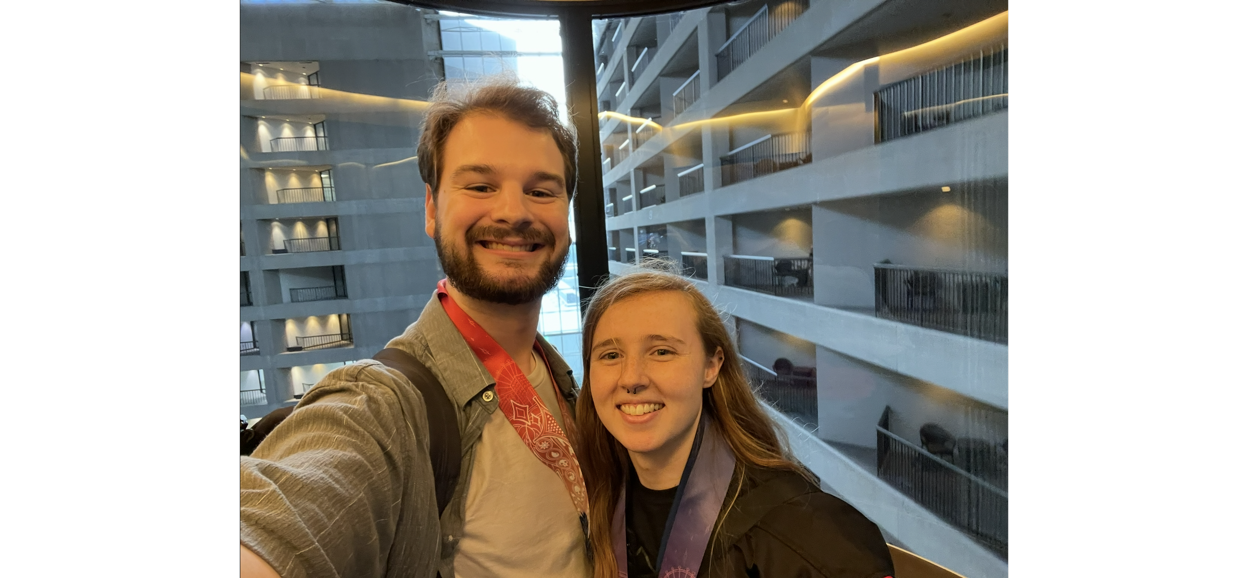 A smiling man and woman taking a selfie in an elevator at a Magiccon for their Honeymoon.
