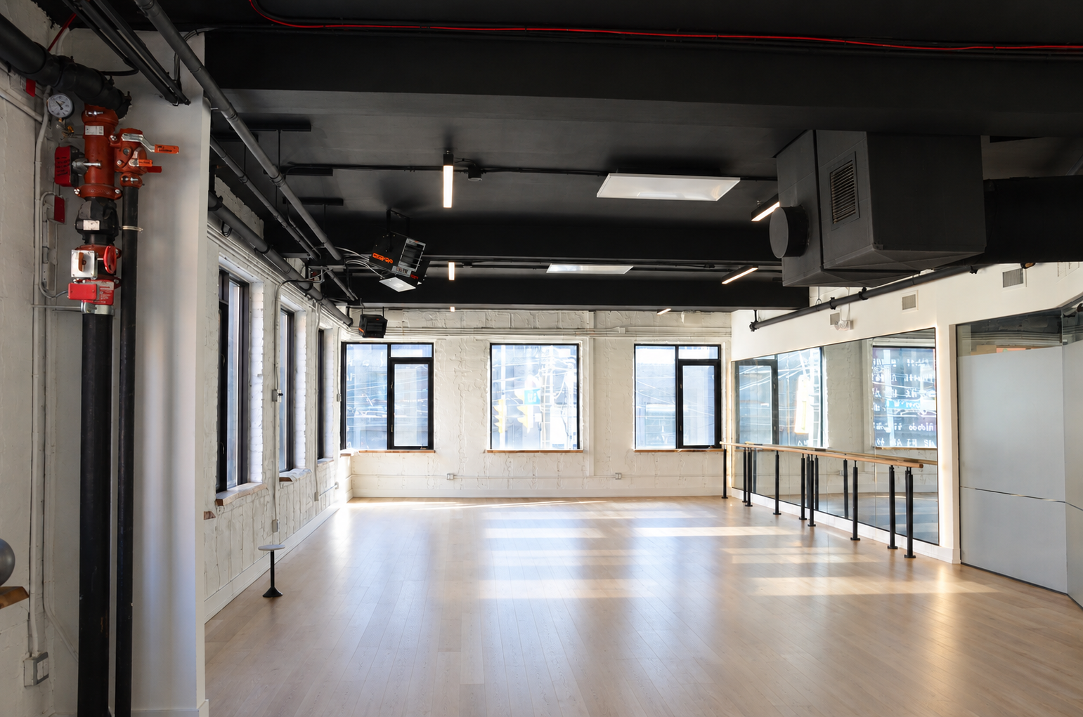 Empty Industrial Studio with Barre and Mirrors (1).png
