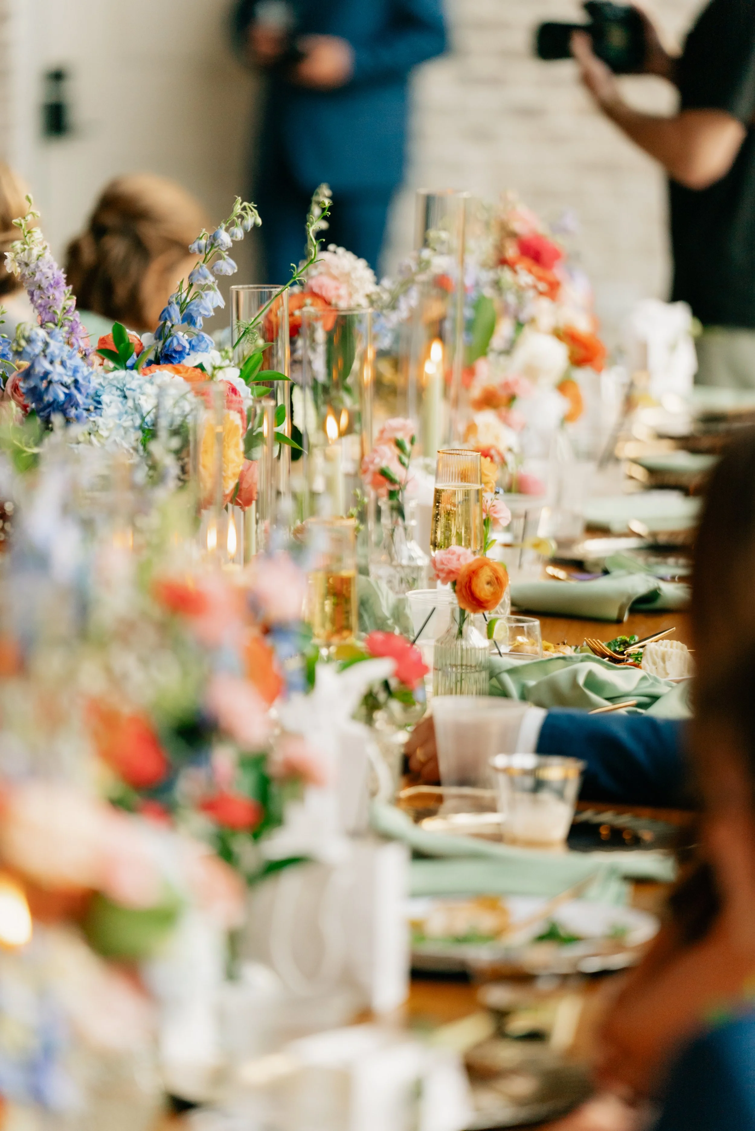 A decorated dining table with floral arrangements and candles, set for a celebration or event.