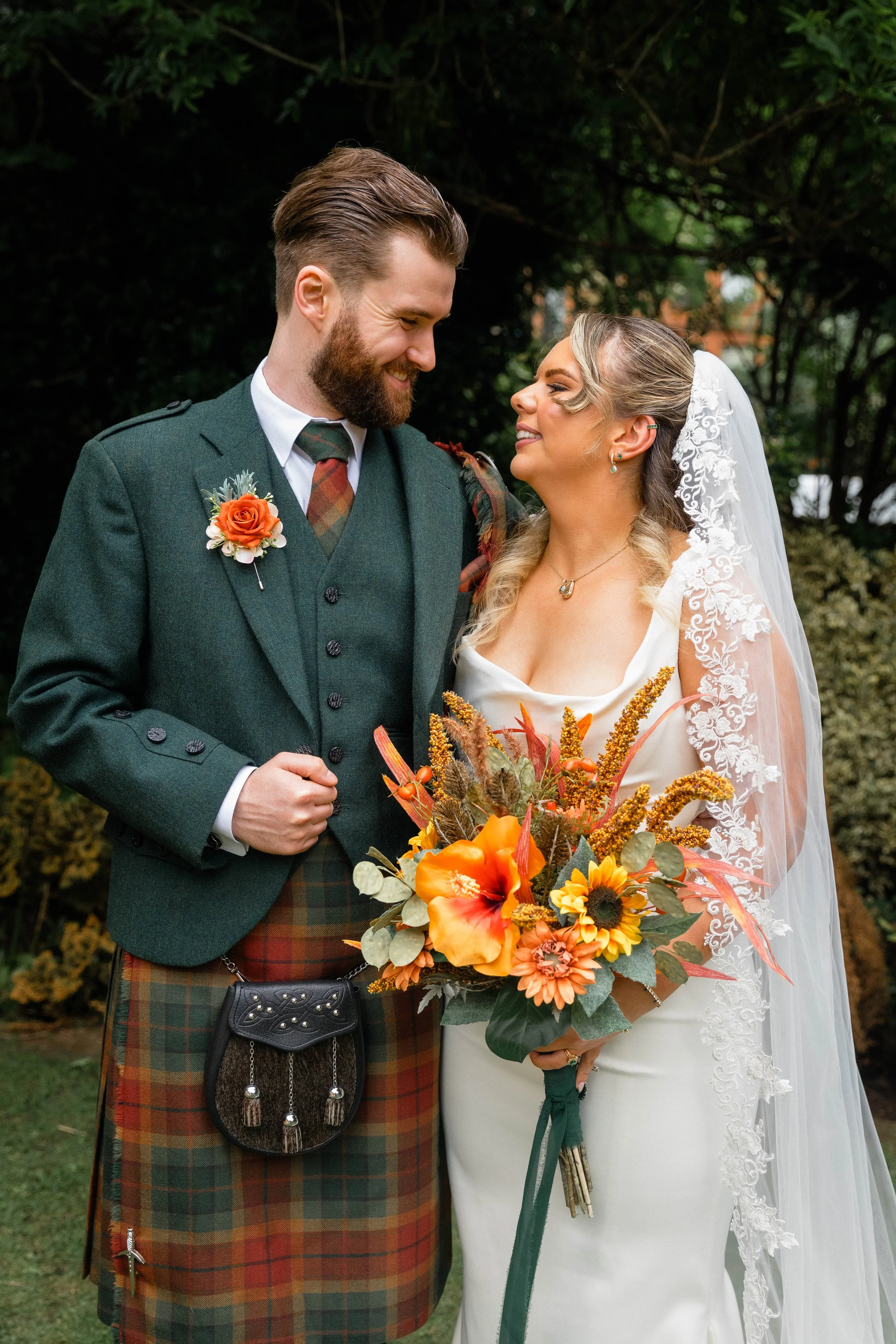 Newly wed couple holding flowers. Glasgow based Love Burds Media specialises in affordable wedding photography and short form video content across Scotland. 