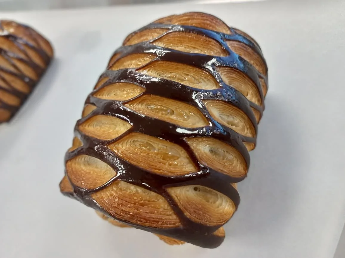 Something new for all chocolate lovers 🍫
Our Pain au Chocolat just got a little glow-up &mdash; a new elegant look, same irresistible taste.
Flaky layers of buttery laminated dough embrace rich, velvety chocolate, baked to golden perfection.

A time