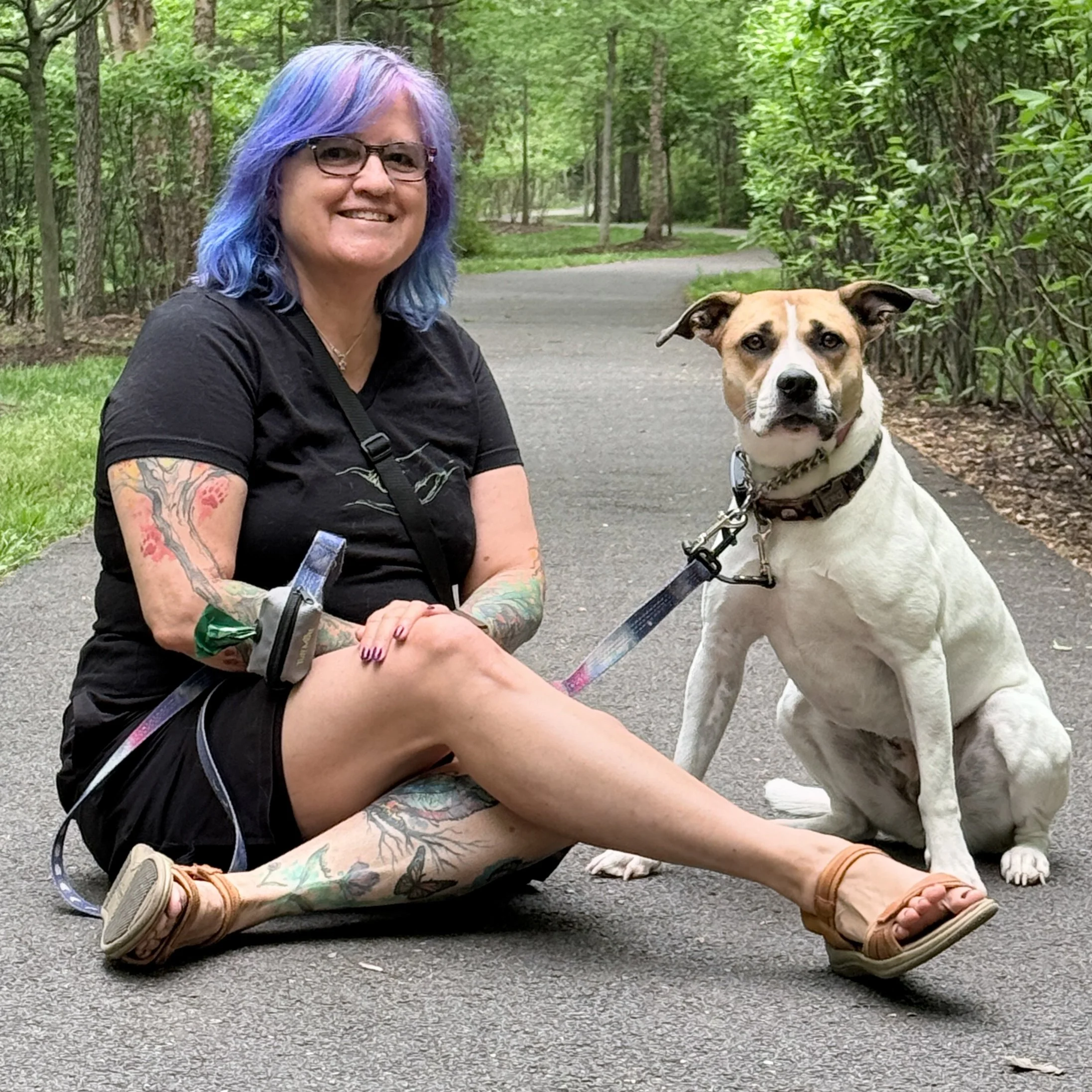 Woman with purple hair with a white and brown dog