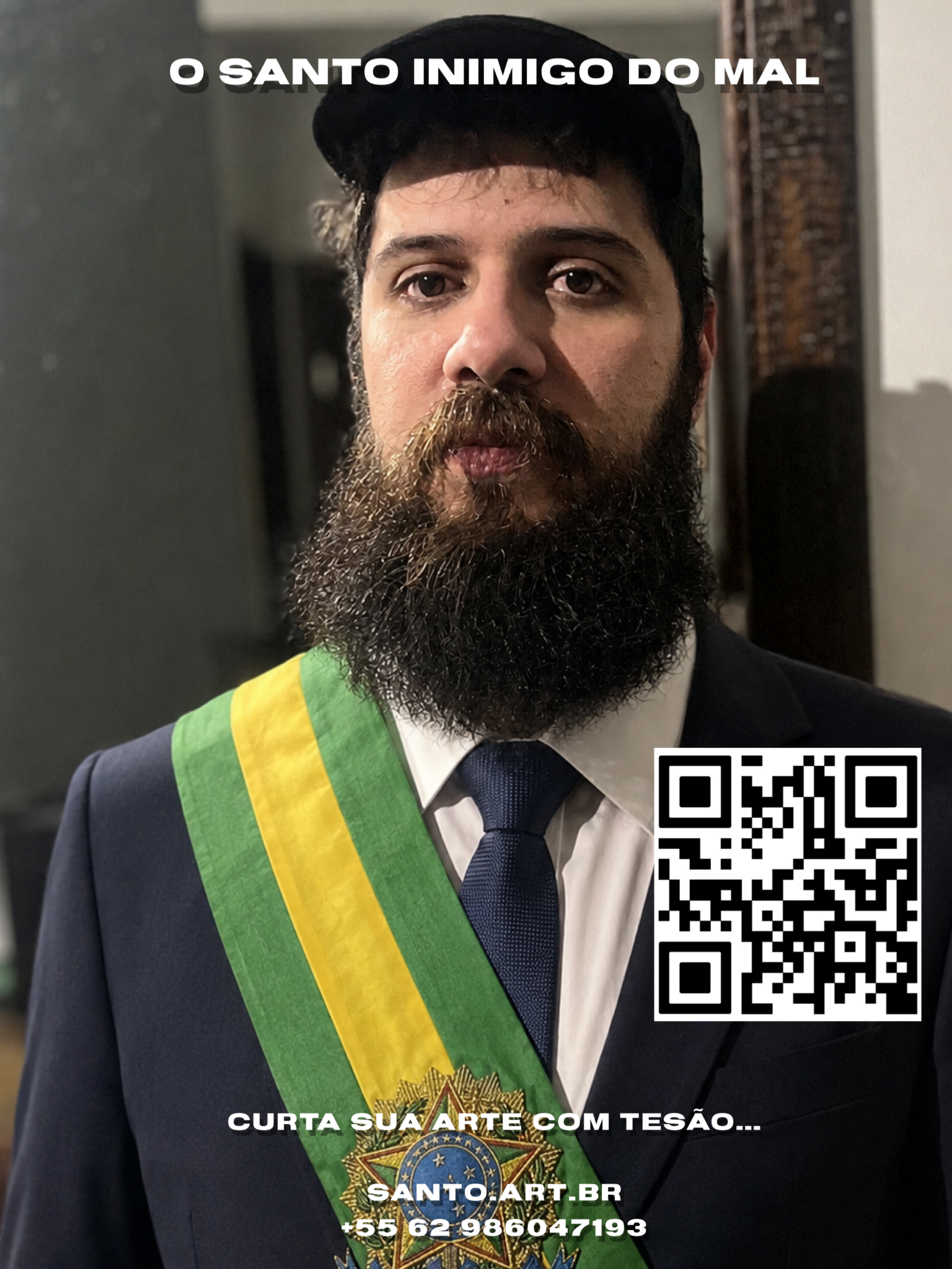 Homem com barba e chapéu, usando terno e gravata, com faixa de triângulo e medalha em seu peito, ao fundo parede com quadro de madeira. Texto acima: 'O santo inimigo do mal'. Texto na parte inferior: 'Curta sua arte com tesão... santo.art.br +55 62 986047193'.