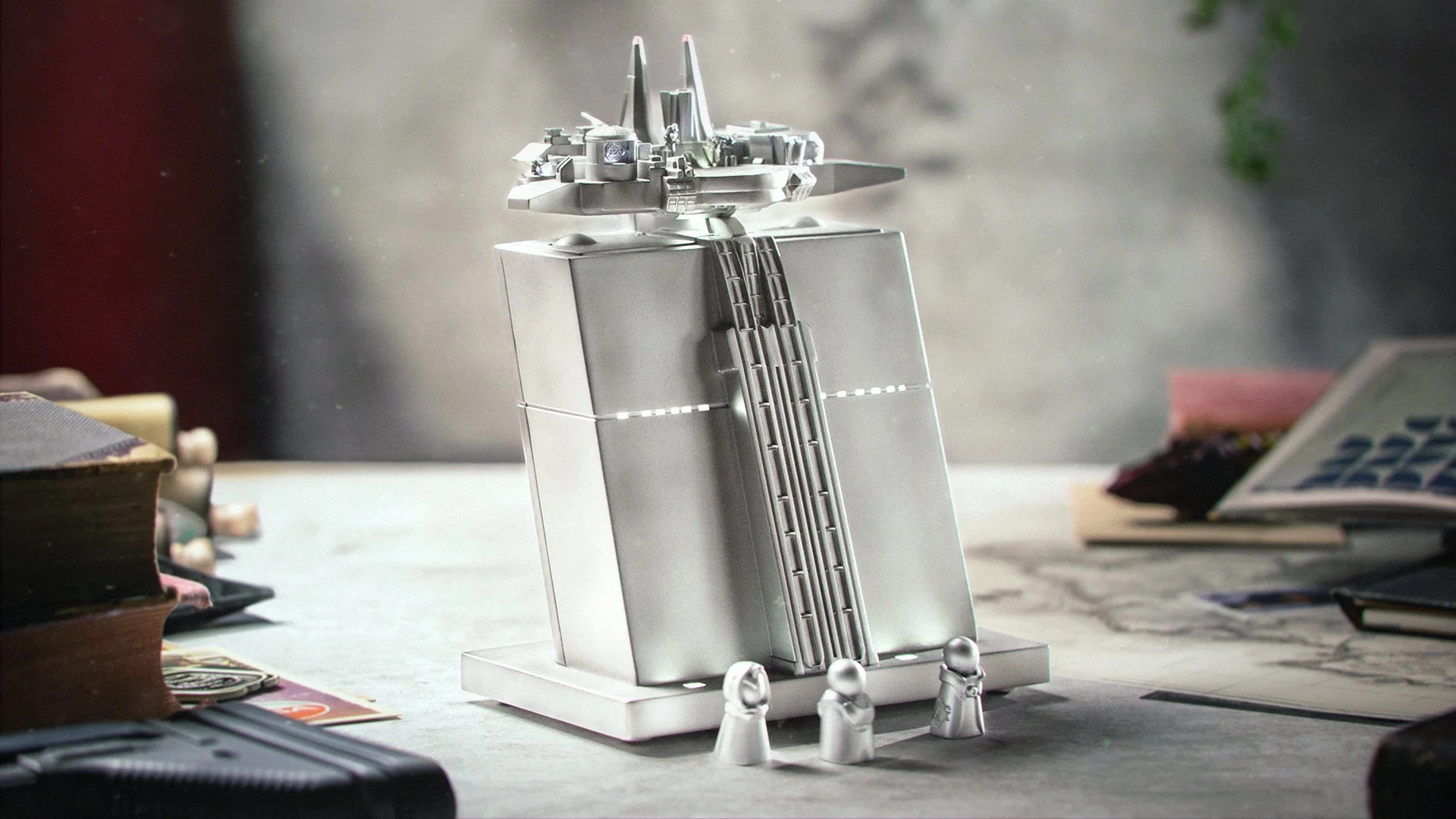 A model spacecraft or satellite mounted on a stand, placed on a desk with books and papers around it.