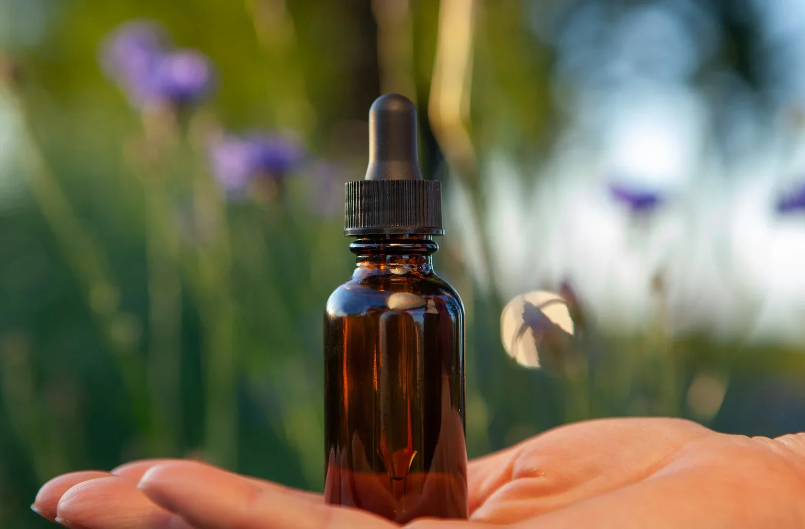 A bottle of flower essences in the palm of a hand