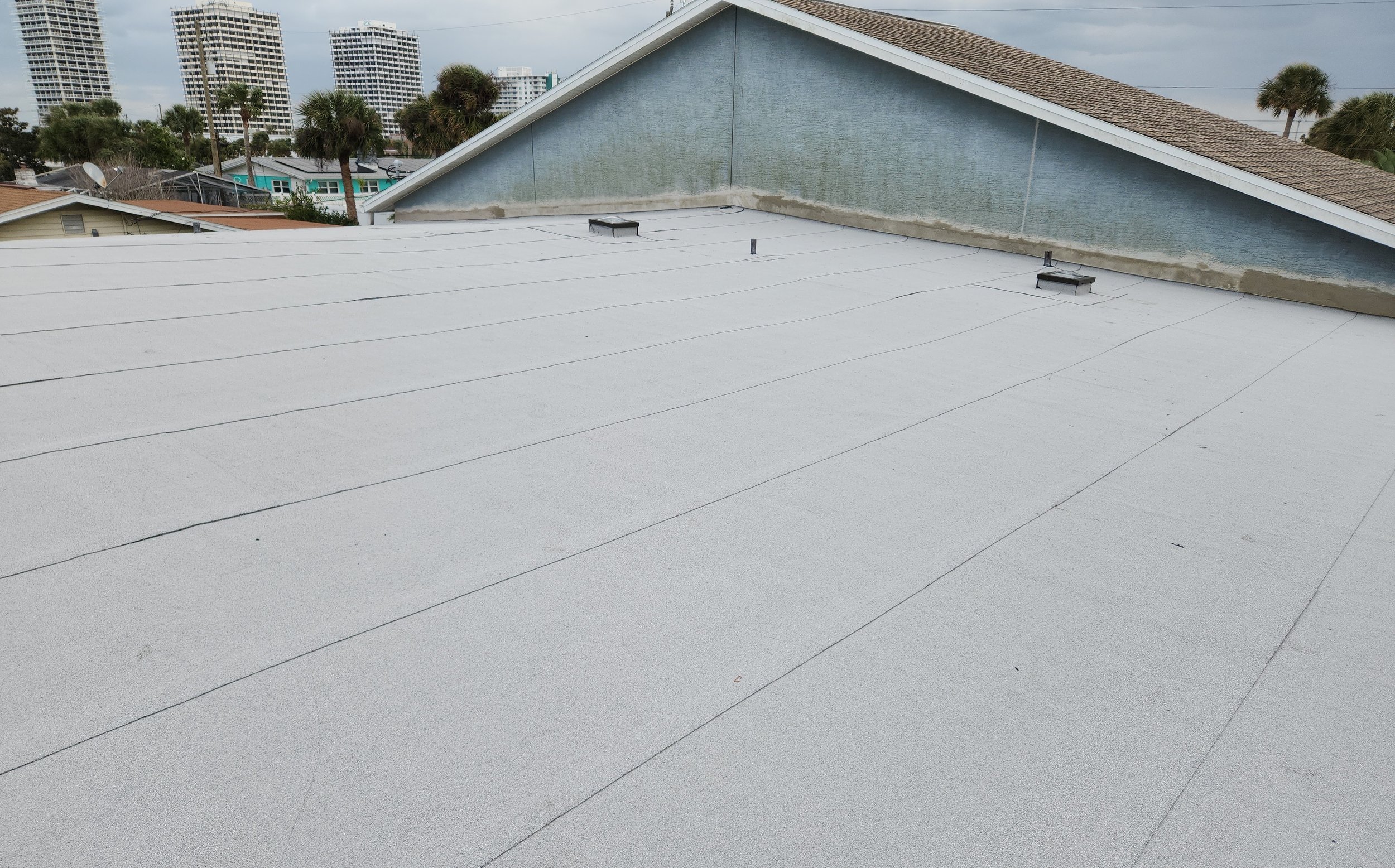 Completed flat roof surface before exterior wall painting, showing smooth, continuous membrane coverage with no seams left exposed. The uniform finish demonstrates proper installation, controlled water flow, and a weather-tight system ready to perfor