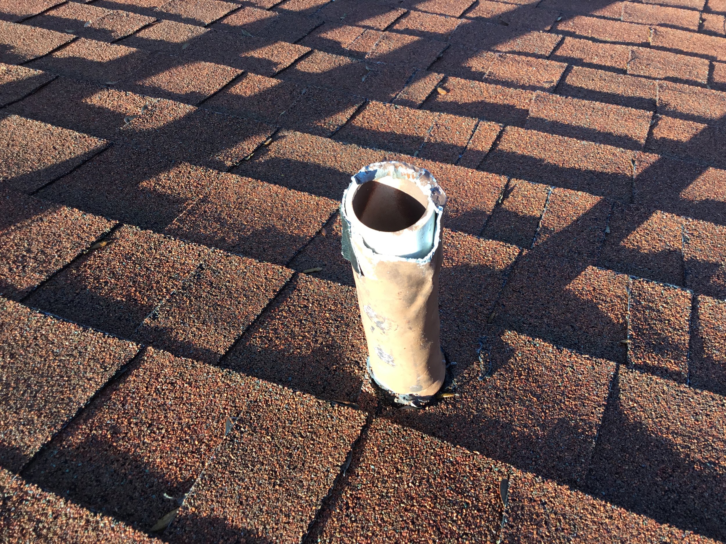 Damaged lead pipe boot on an asphalt shingle roof, showing common cracking and separation that allows water intrusion around roof penetrations. This type of failure often develops with heat and aging, which is why Skyline Detailed Roofing replaces le