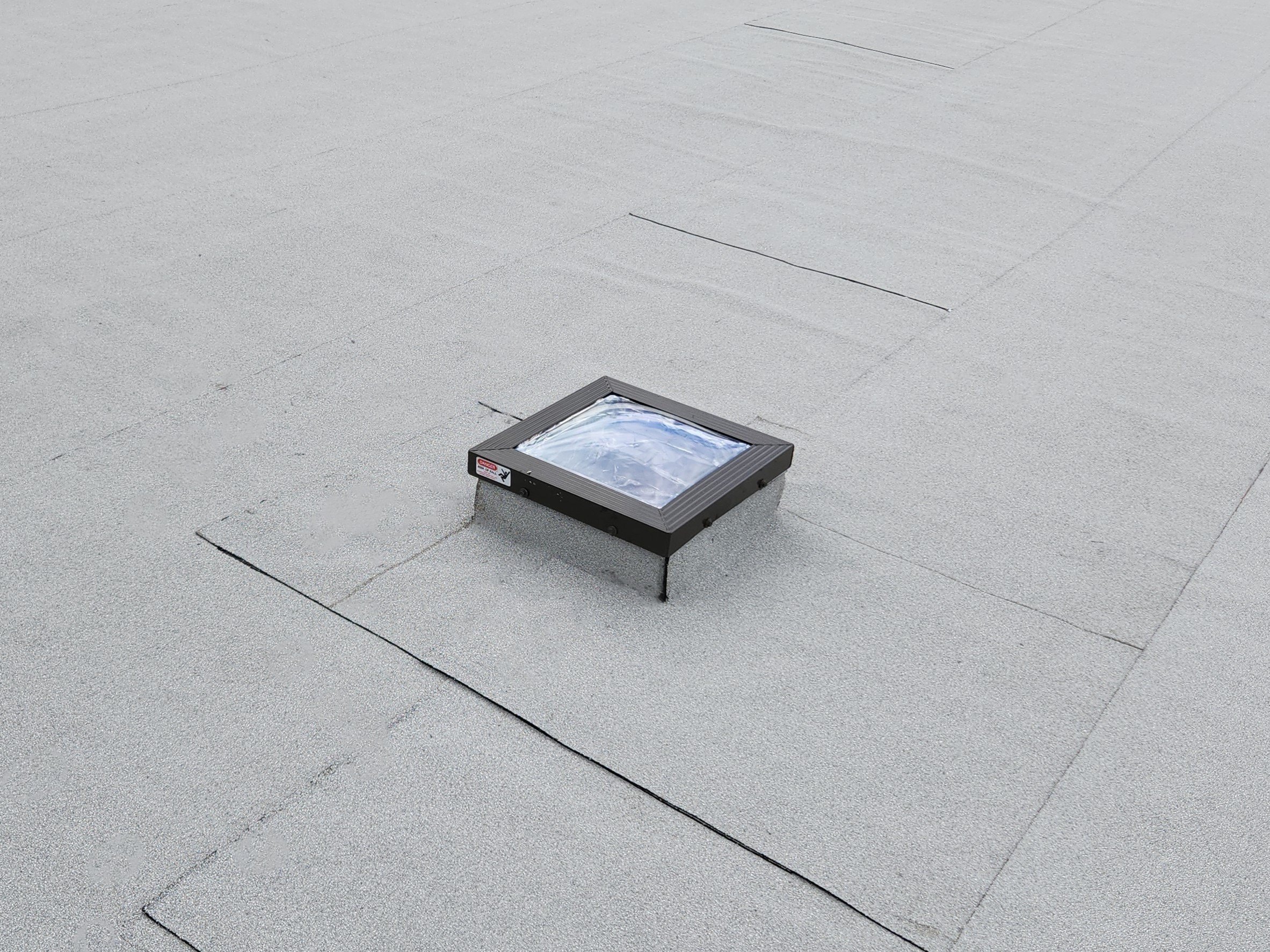 Curb-mounted skylight integrated into a Daytona Beach flat roof, fully flashed and tied into the membrane system to keep water out while allowing natural light in. Correct detailing around penetrations like this is critical in coastal environments wh