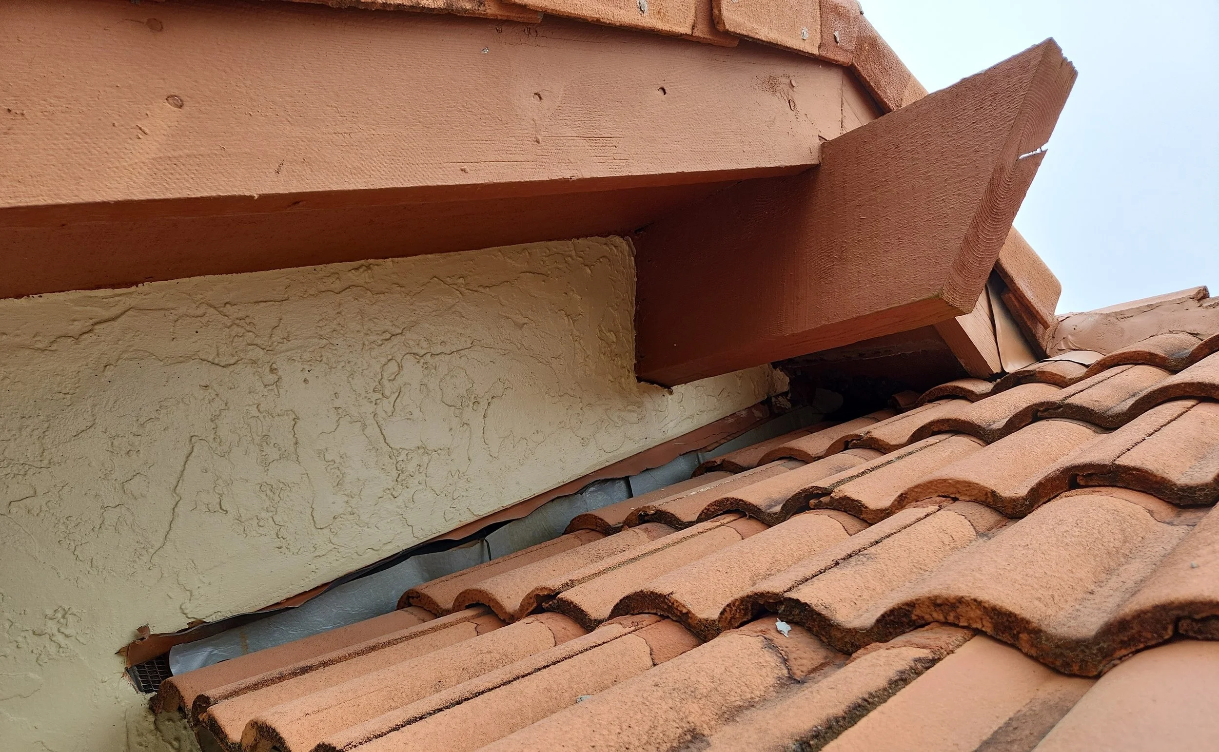 Concrete tile roof previously replaced by another contractor using old tiles and reusing flashing — installed incorrectly and without proper waterproofing. The shortcuts led to widespread leaks and structural damage beneath the tiles, ultimately requ