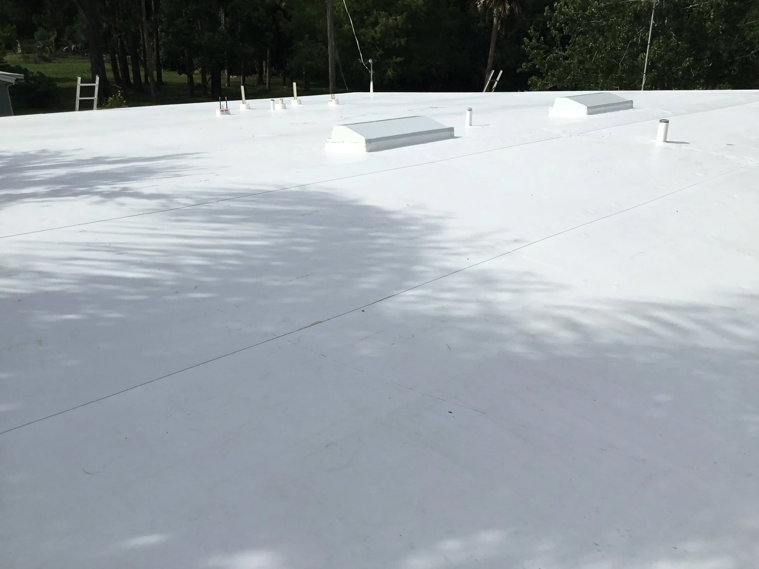 Completed white TPO (thermoplastic polyolefin) roof on a Port Orange residence, creating a seamless, highly reflective surface that reduces heat gain and improves energy efficiency. This modern membrane system provides excellent waterproofing, UV res