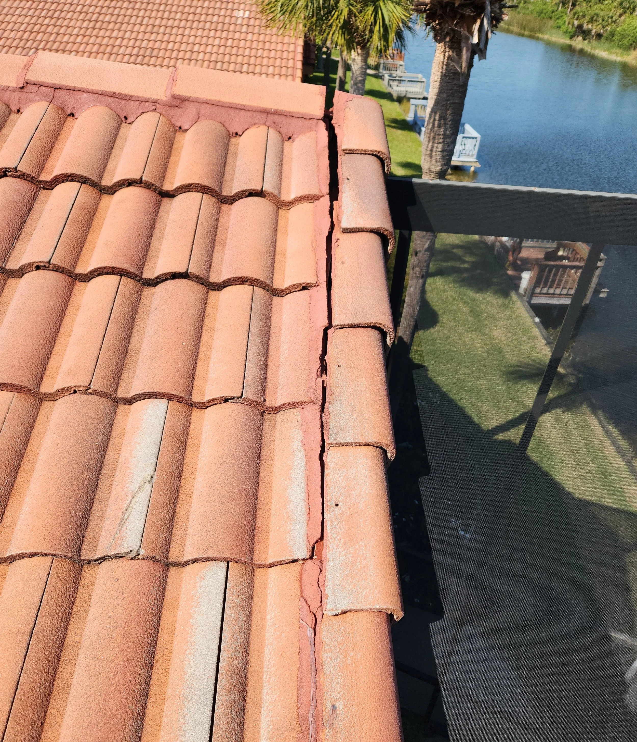 Separated caps on a concrete tile roof showing mortar cement separation