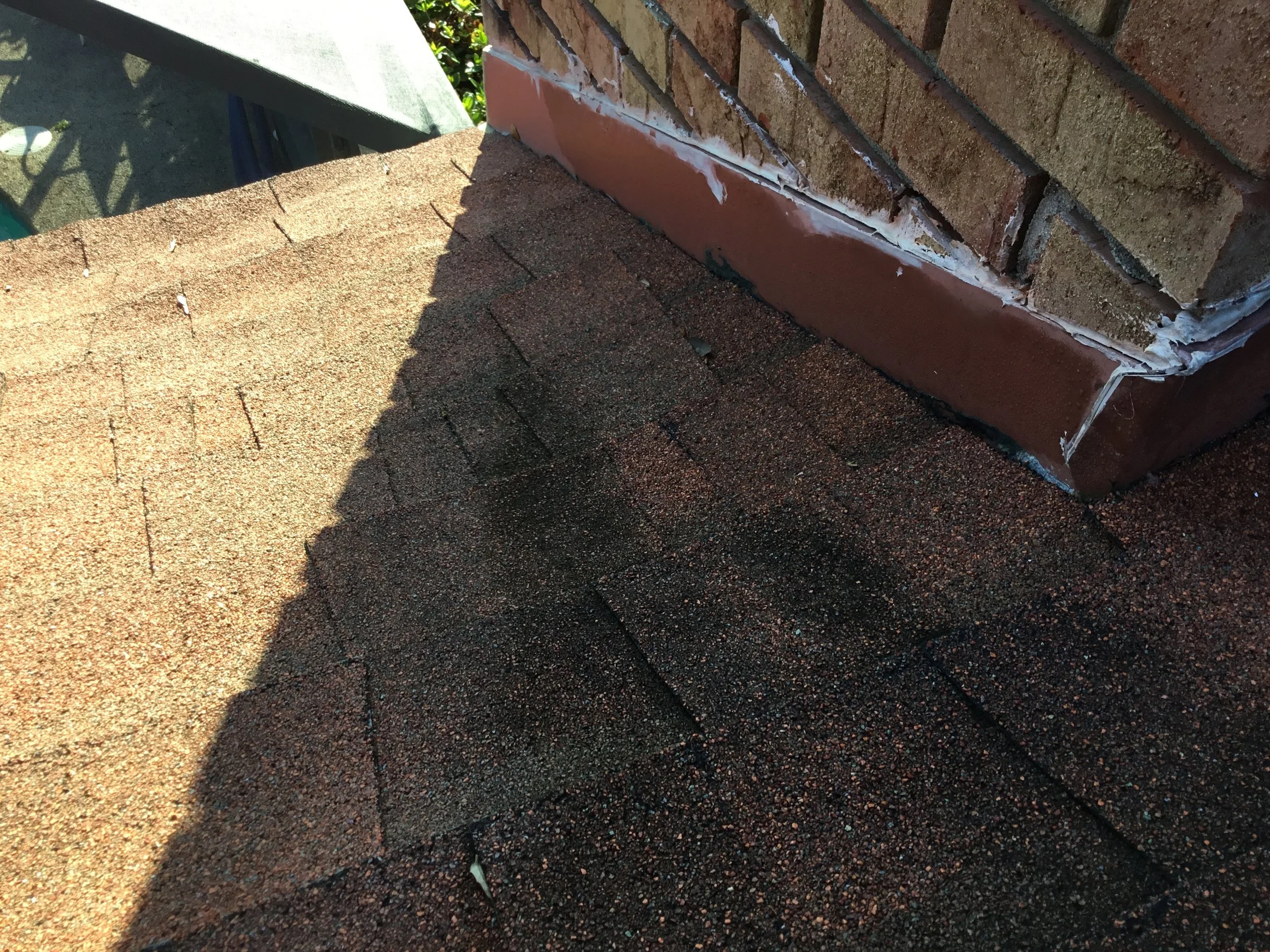 Improper flashing at a roof-to-brick intersection, where exposed metal and reliance on caulking left the joint unprotected from water intrusion. Sealant alone degrades in Florida’s heat and UV, making this a predictable leak point — exactly the type 