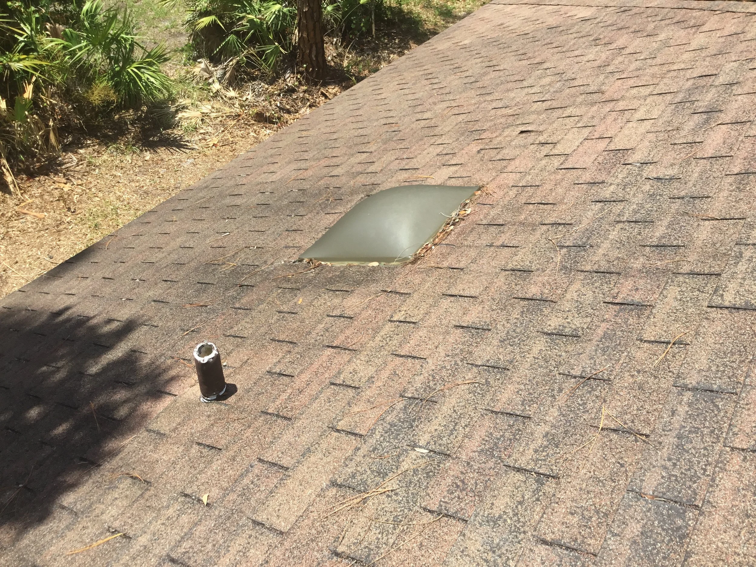 Aging asphalt shingle roof featuring an older plastic dome skylight — a design that is more prone to cracking, yellowing, and leakage over time. Modern replacements use high-impact, insulated glass skylights that are stronger, more energy efficient, 