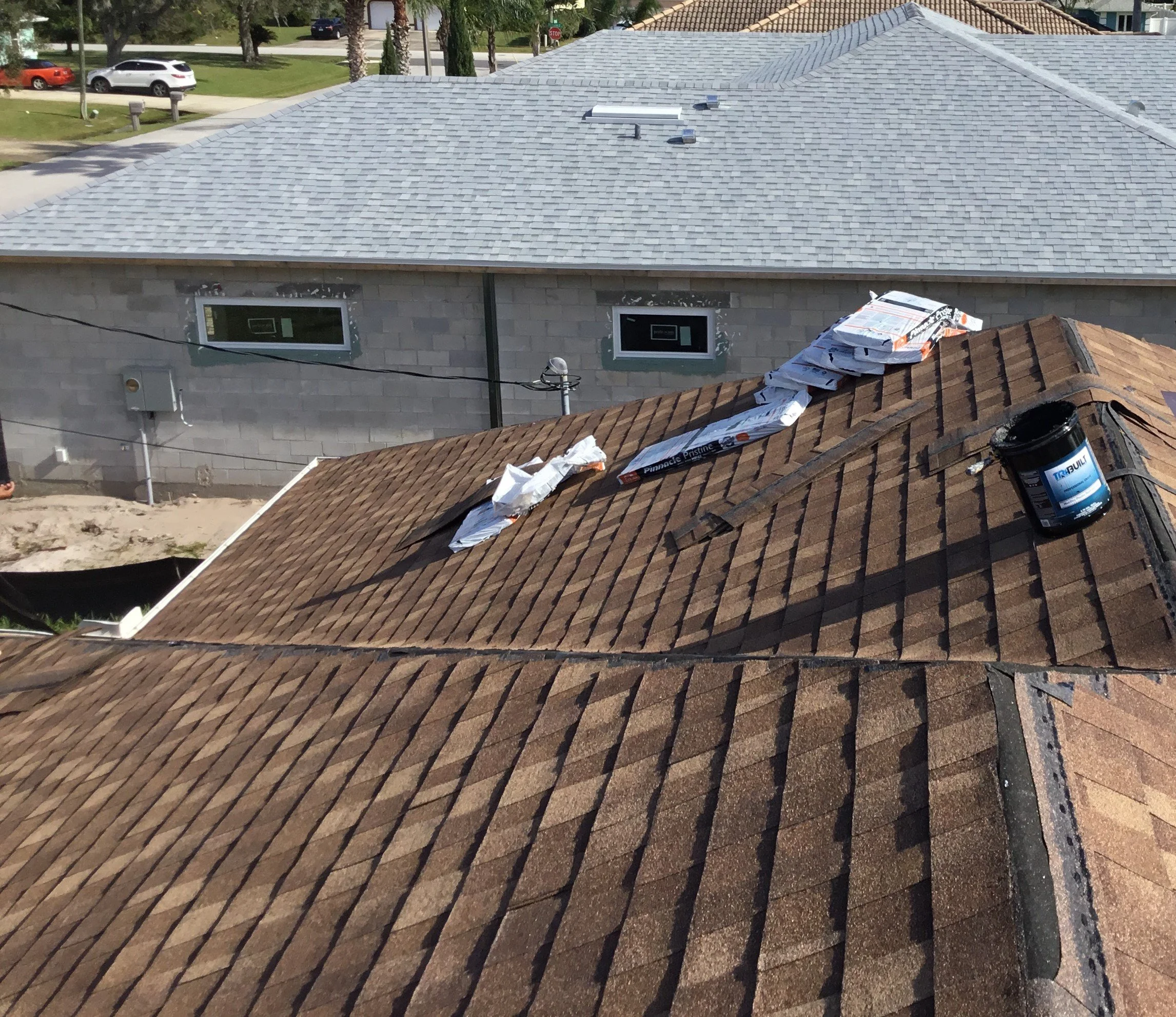 Architectural shingle roof in progress just before ridge cap installation, showing clean field courses ready for final detailing. Proper sequencing at this stage ensures straight ridge lines, correct nailing patterns, and a finished roof that perform