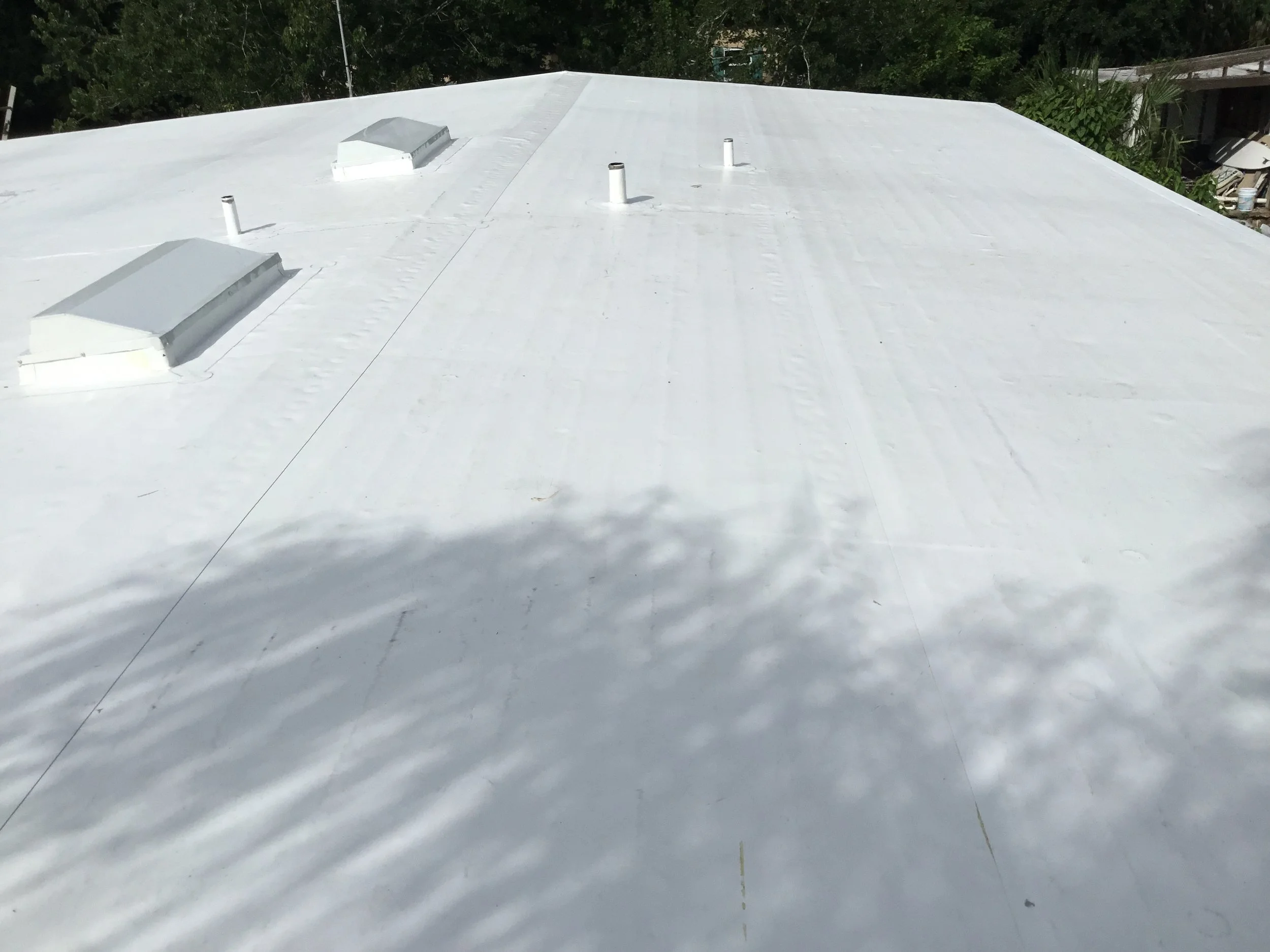 Close view of TPO roof penetrations properly flashed and heat-welded to the main membrane, ensuring continuous waterproof protection around vents and rooftop equipment. Clean detailing at these transition points is what prevents leaks and keeps a fla