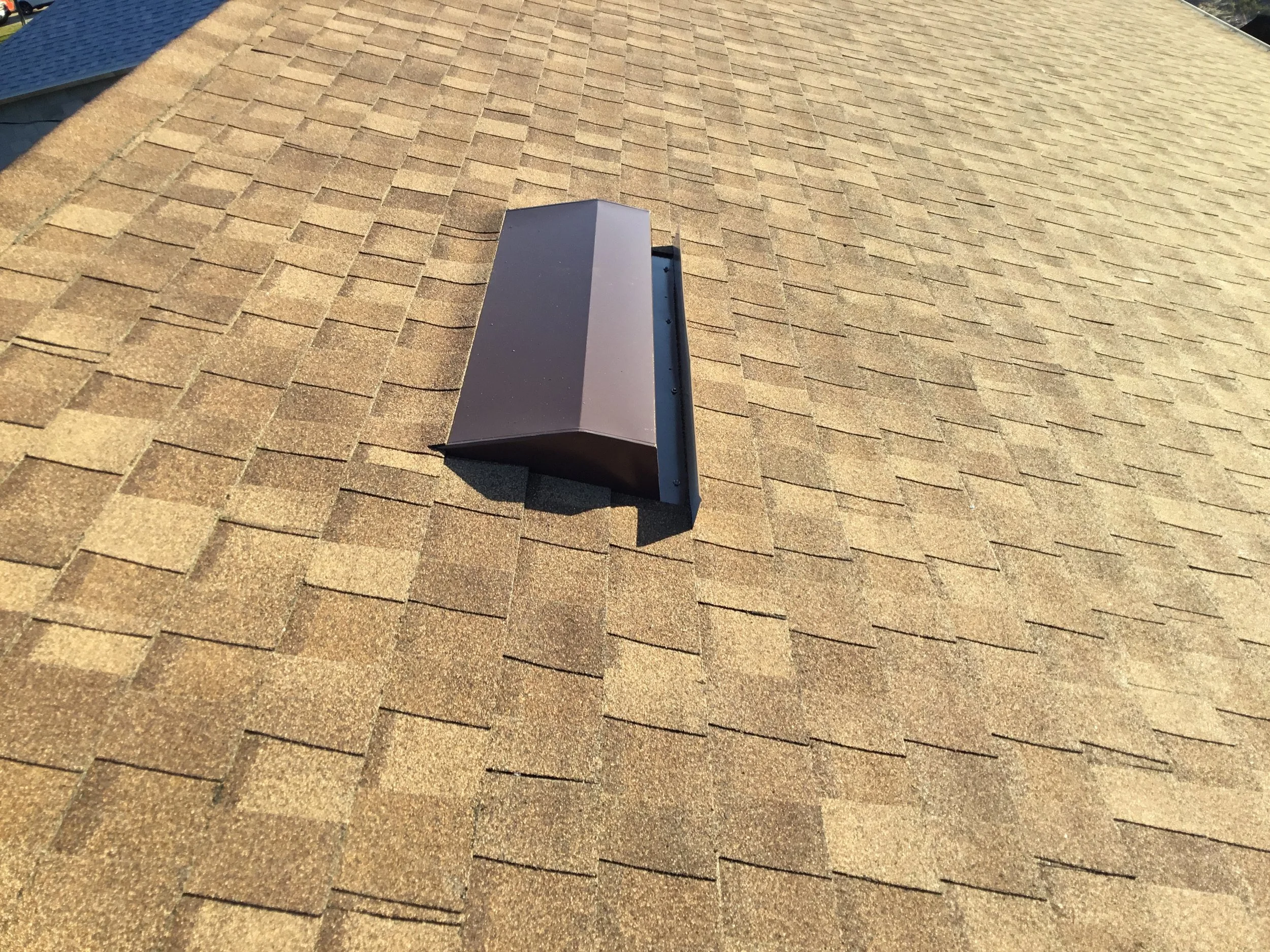 Close view of a modern off-ridge vent integrated near the roof peak, allowing continuous attic airflow while keeping weather protection intact. Proper vent installation like this reduces heat buildup, improves moisture control, and extends shingle li