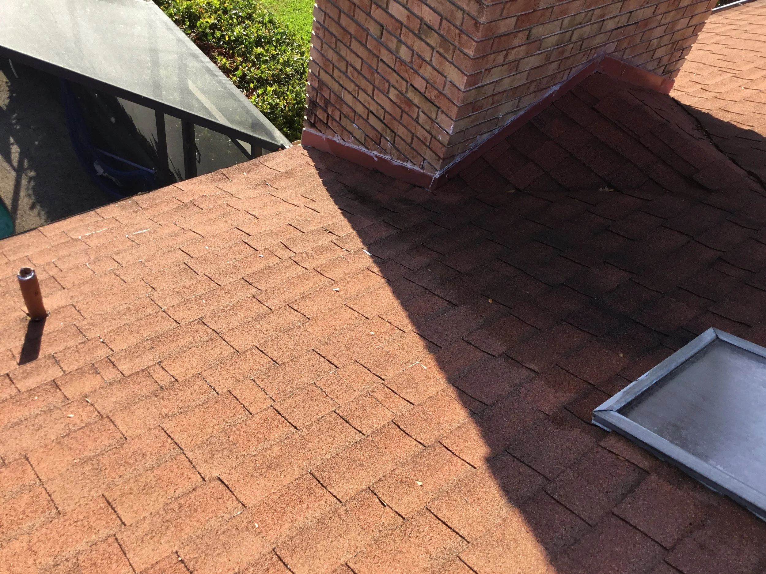 Aging asphalt shingle roof showing visible surface wear, granule loss, and uneven texture typical of a roof nearing the end of its service life. While still intact in areas, this level of deterioration increases the risk of leaks and storm damage — m