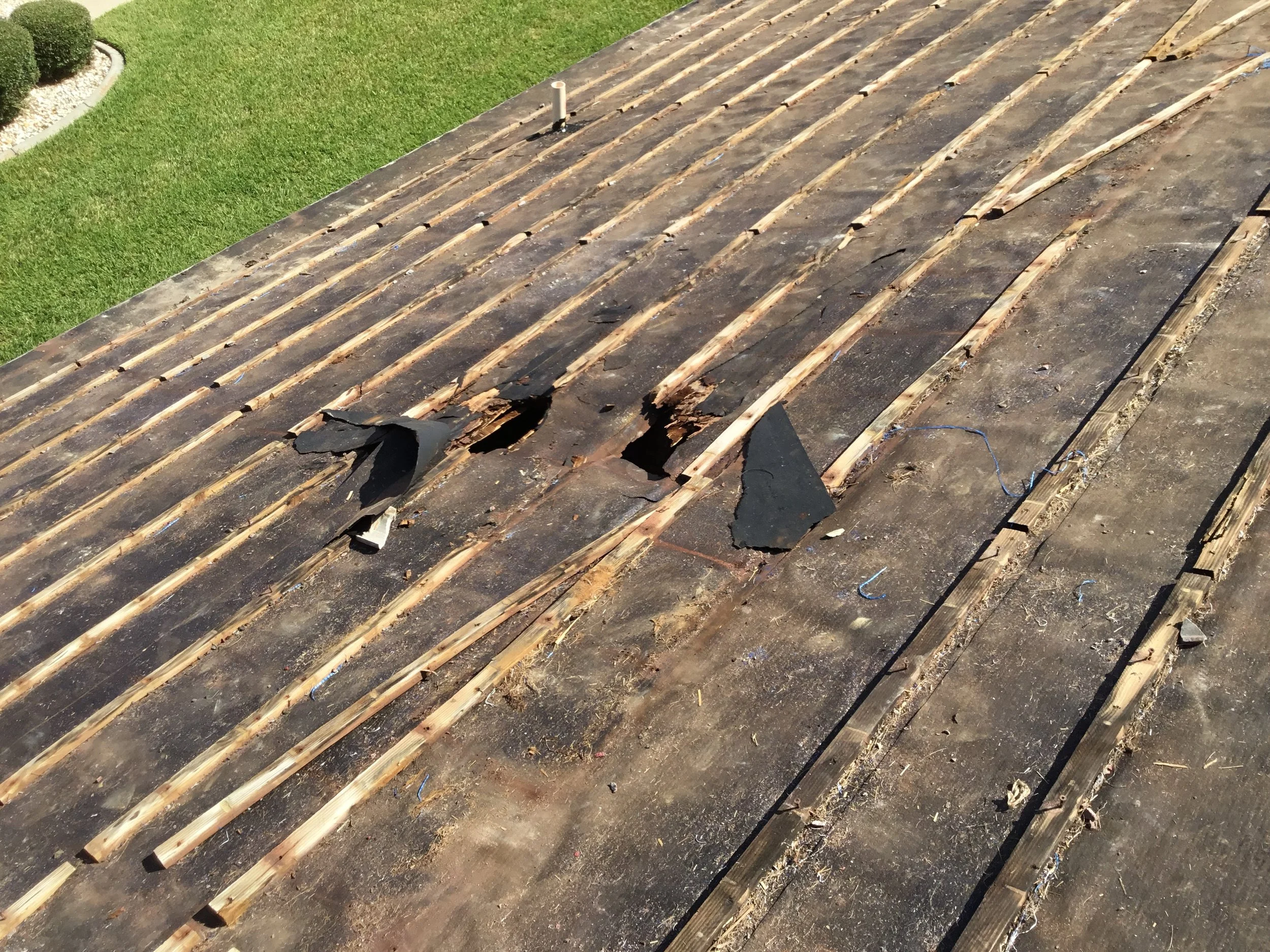 Clay tile roof showing storm damage where cracked and displaced tiles exposed the layers beneath. Once tiles are broken or missing, water can quickly reach the underlayment and decking — making prompt repair or full replacement essential to prevent h