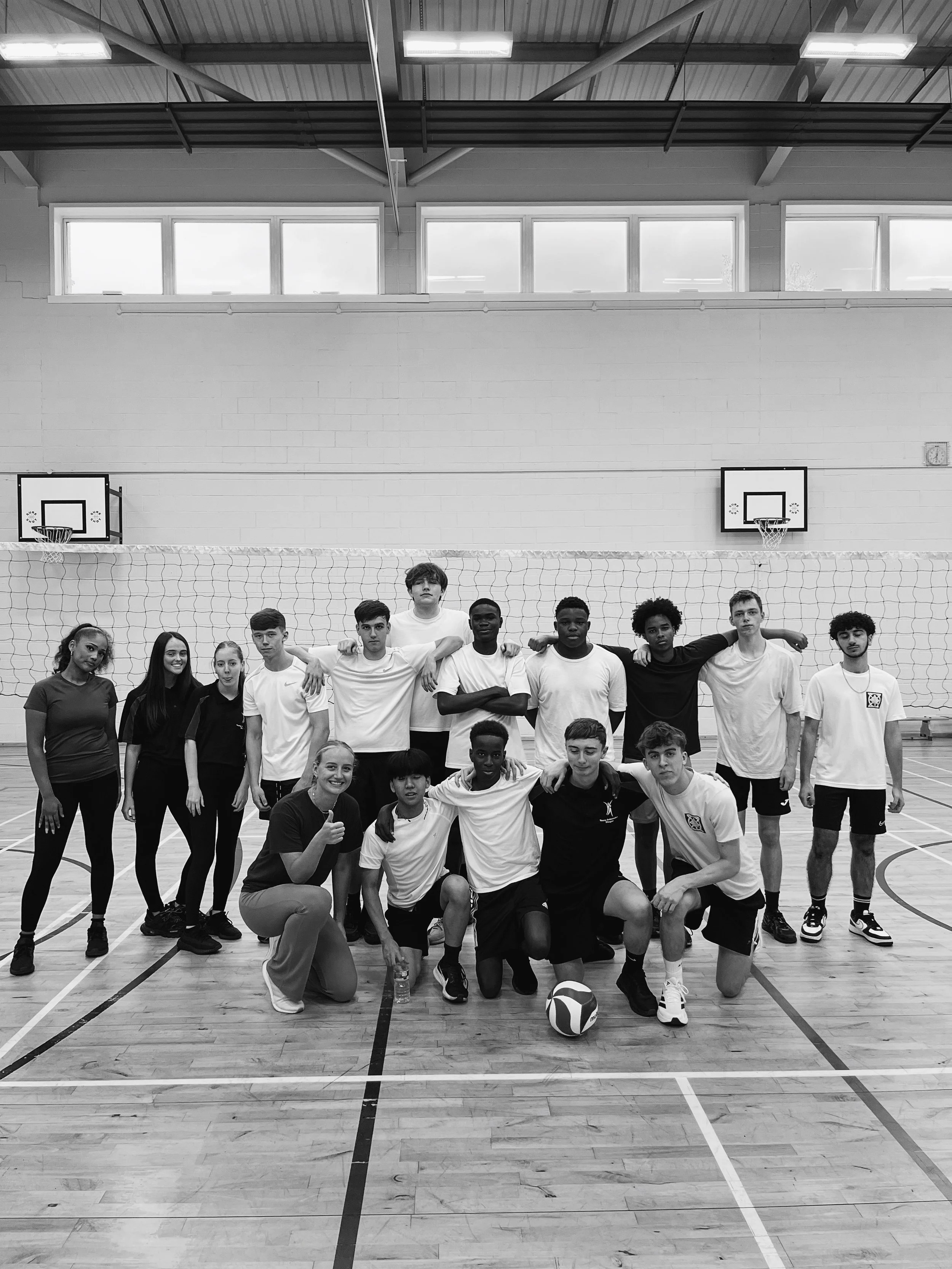 Scottish Volleyball team group photo with players and coaches gathered on indoor court in black and white