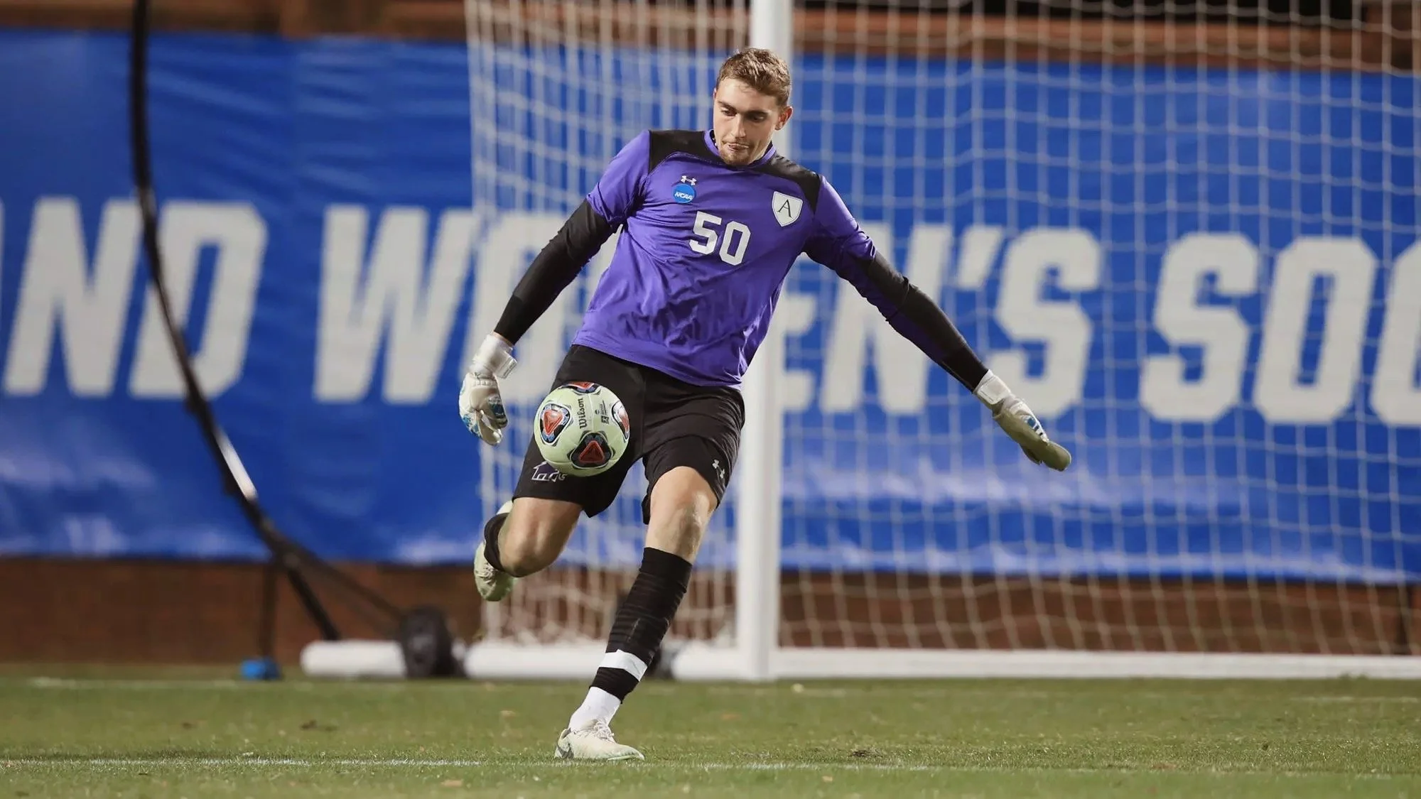 Bernie White making a save in purple Amherst College goalkeeper jersey during NCAA match for Amherst College Men's Soccer