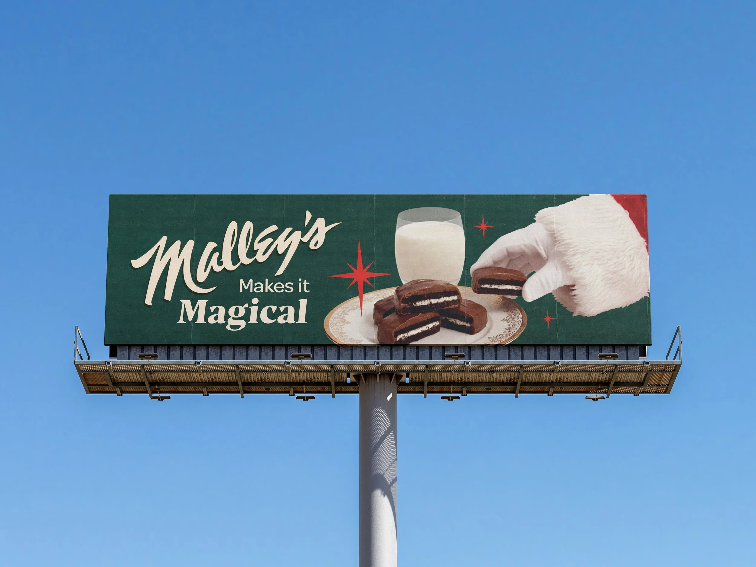 Billboard advertising Mallory's, featuring a Santa hands, a glass of milk, and chocolate cookies, with text 'Mallory's Makes it Magical'.
