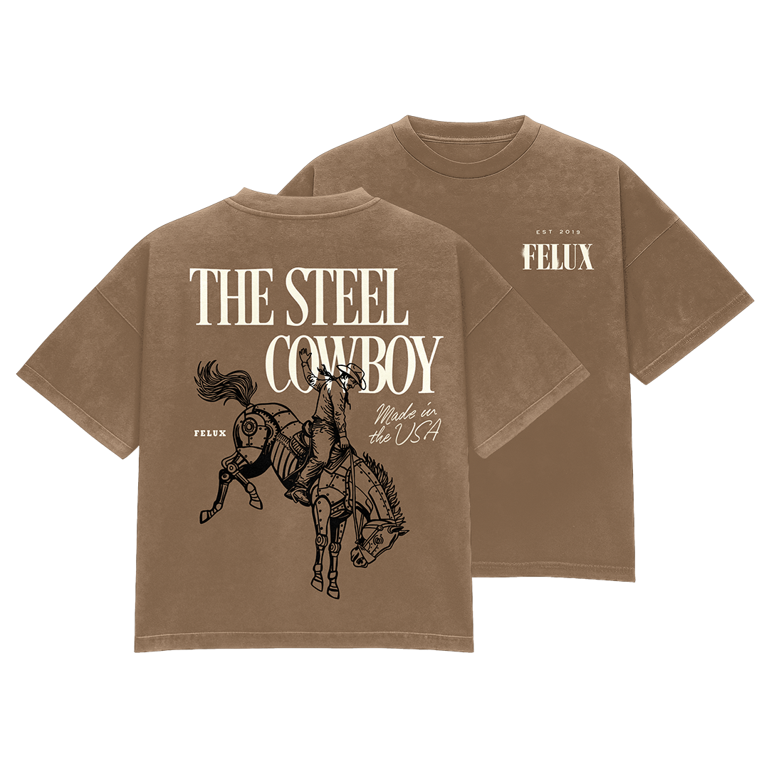 Brown T-shirt with a graphic of a cowboy riding a robotic horse, text 'The Steel Cowboy' and 'Made in the USA', and smaller text 'Felux' and 'Est 2019'.