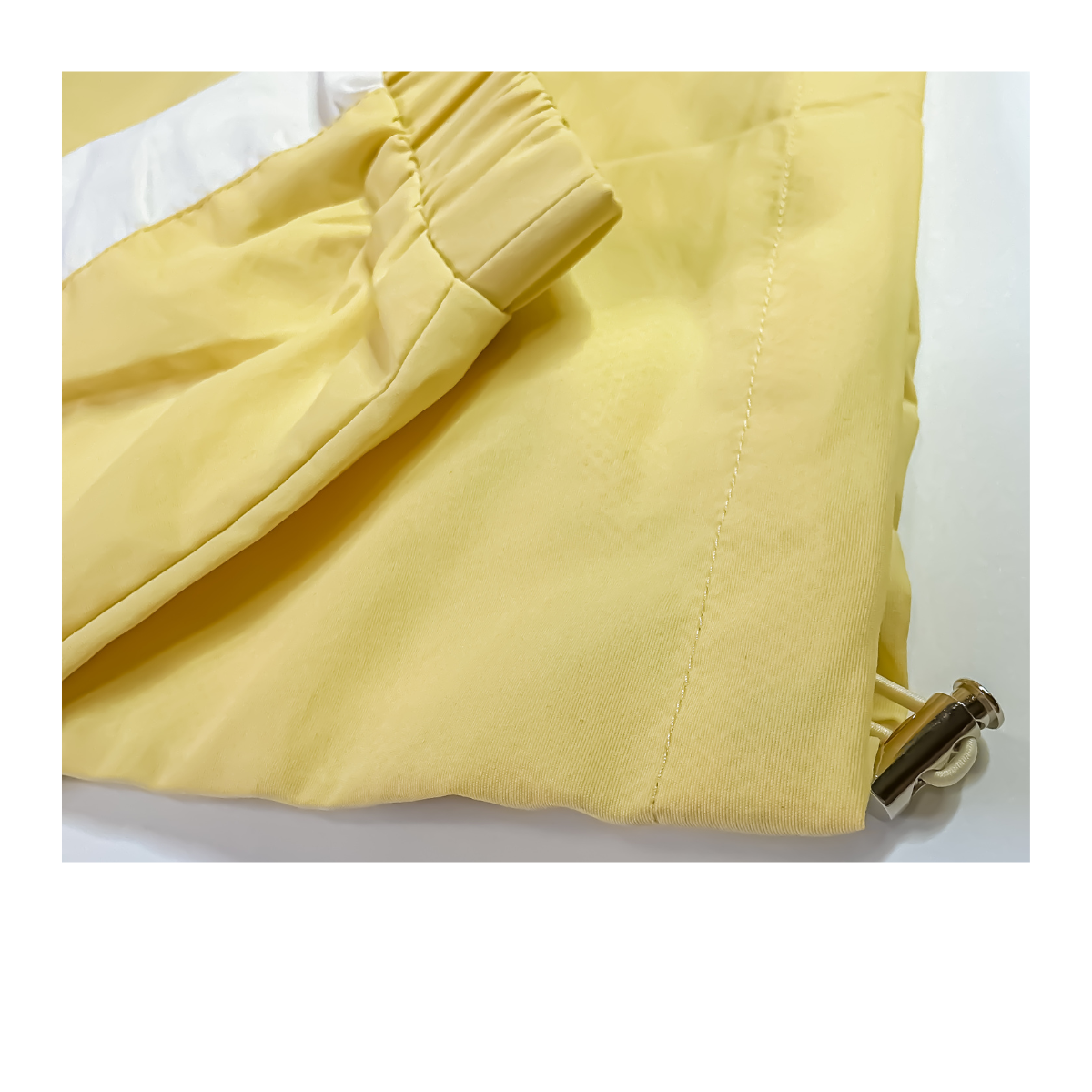 Close-up of a yellow drawstring bag with a metal cord lock.