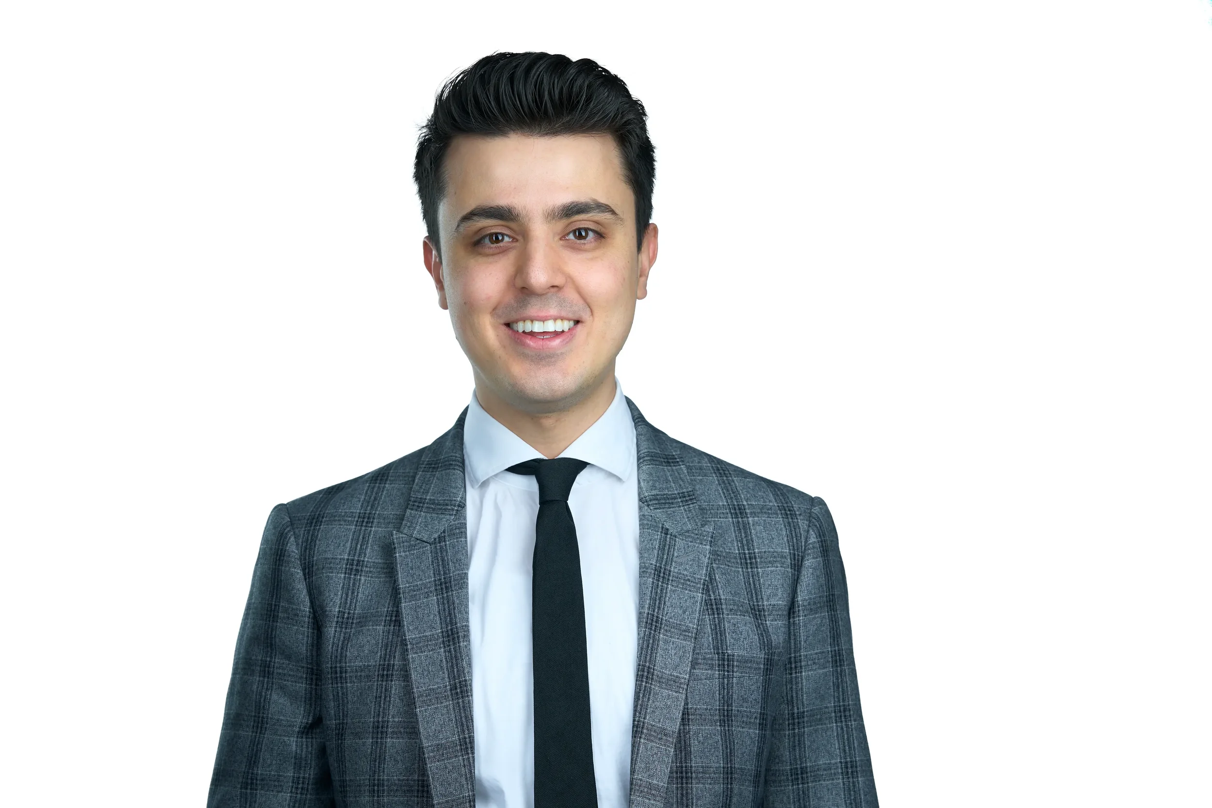 Young man in a gray plaid suit, white shirt, and black tie smiling against a white background.