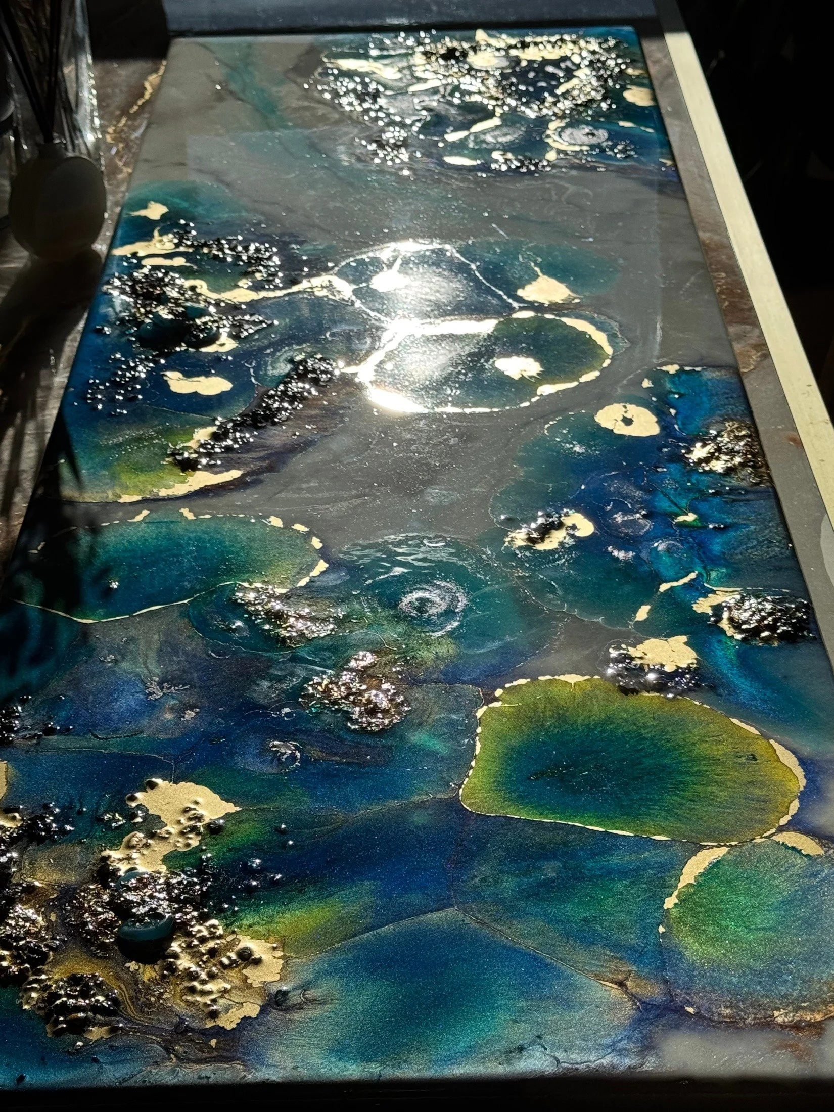 Celestial Depths
2025 · 125 × 46 × 5 cm
Resin, pigments, crystals, wood, gold pigments, and gold and silver leaf.
Ocean blues, turquoise and luminous metallic accents bring together underwater and celestial landscapes.
Sold — shown as part of the art