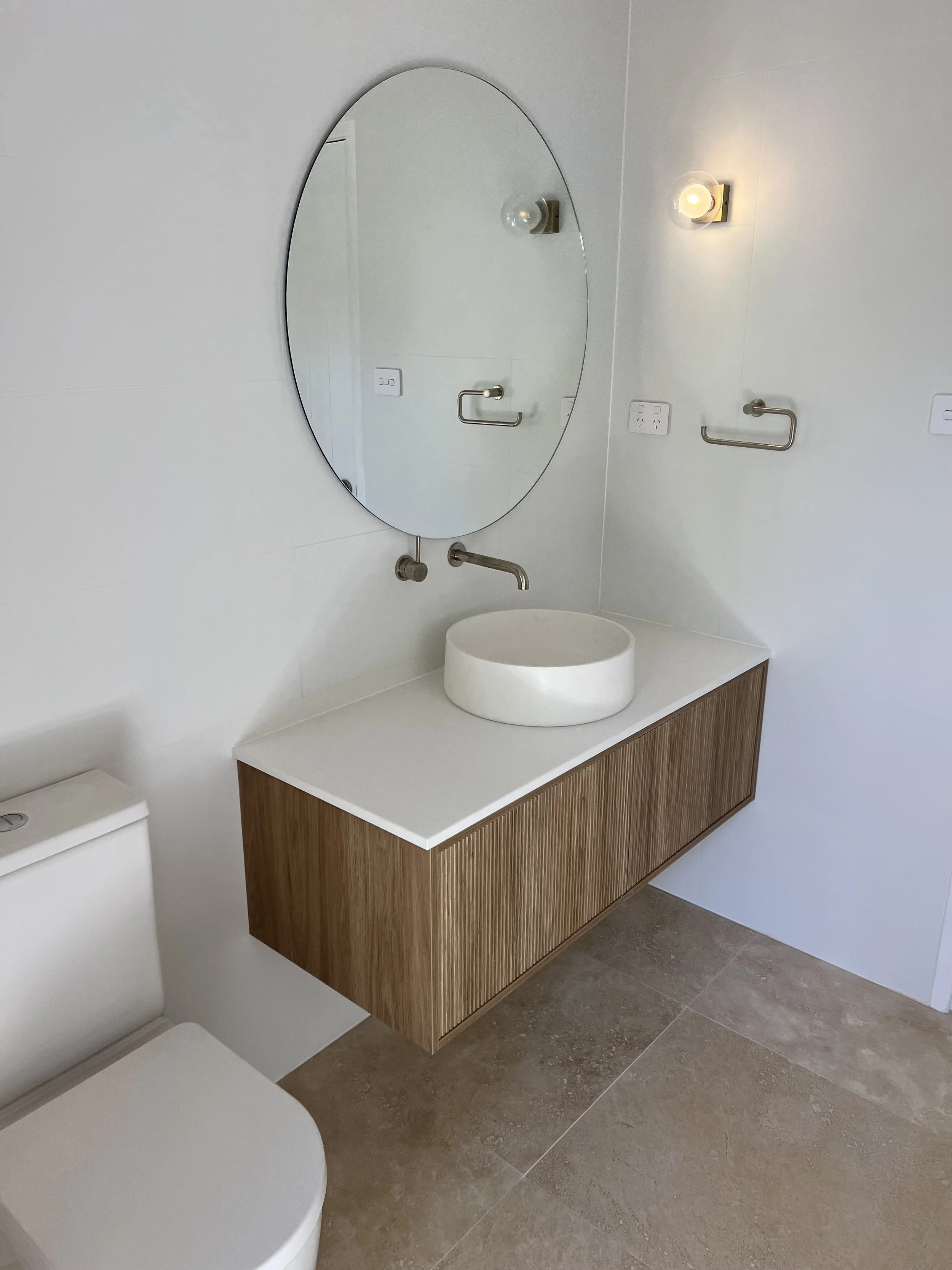 Modern bathroom with a white wall-mounted sink, renovation in margaret river region by local builder