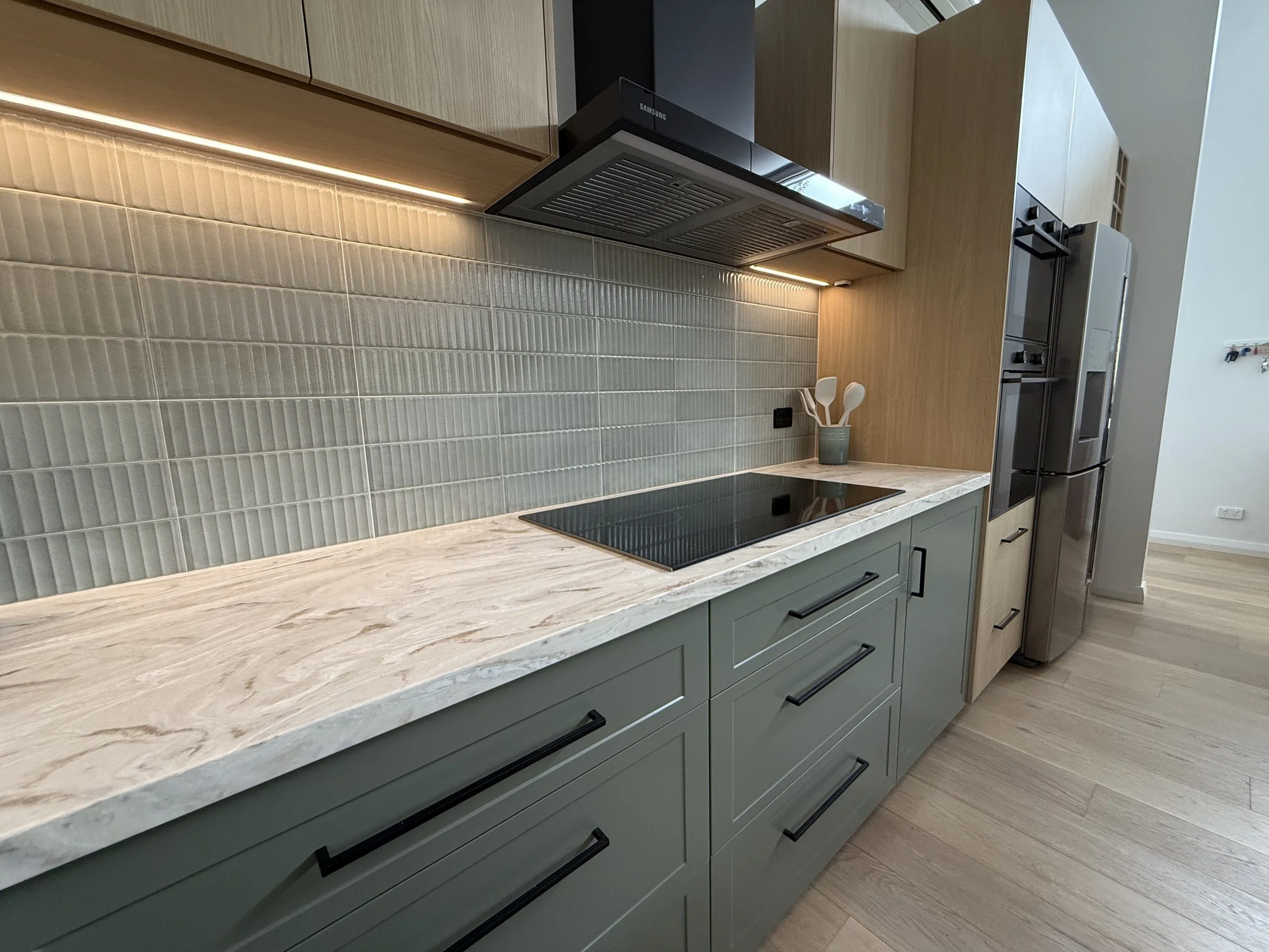 Completed modern kitchen build with light wood and gray cabinetry in custom home build by south west WA builder