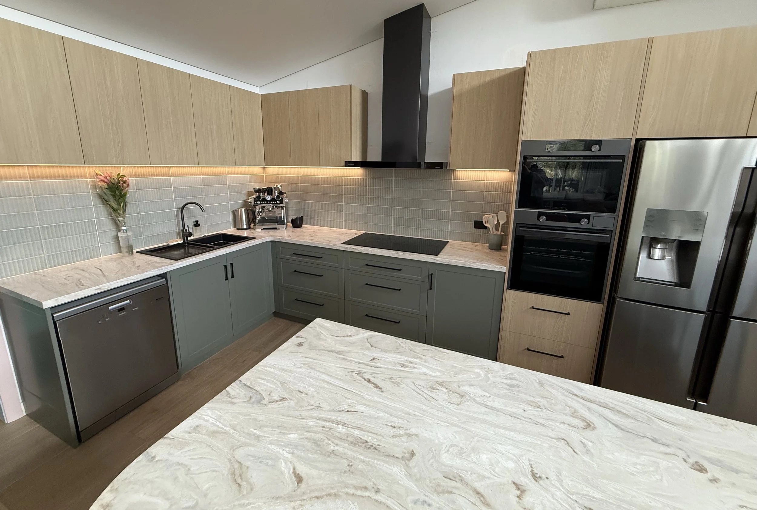 Completed modern kitchen build with light wood and gray cabinetry in custom home build by south west WA builder