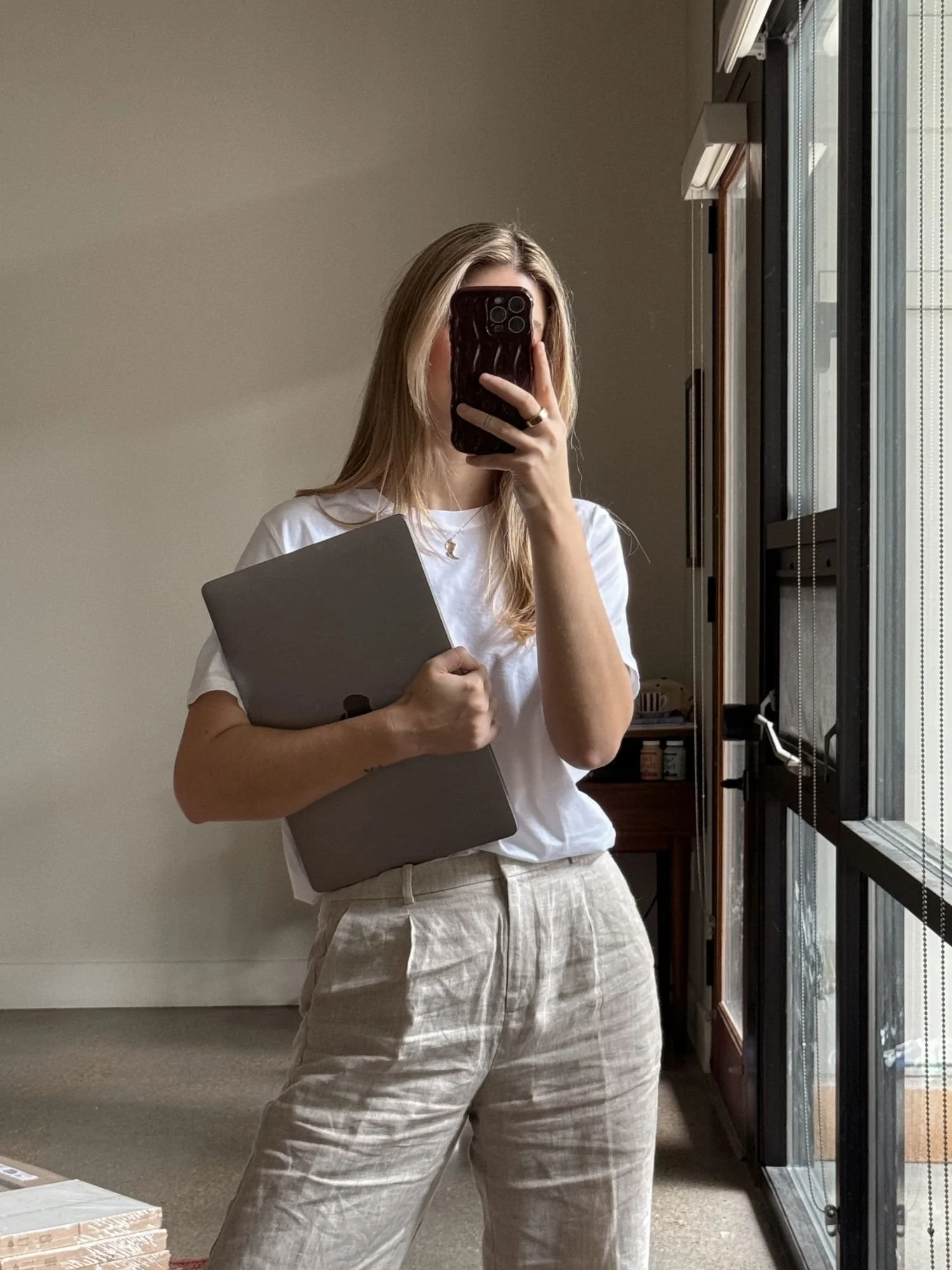 girl holding macbook and phone