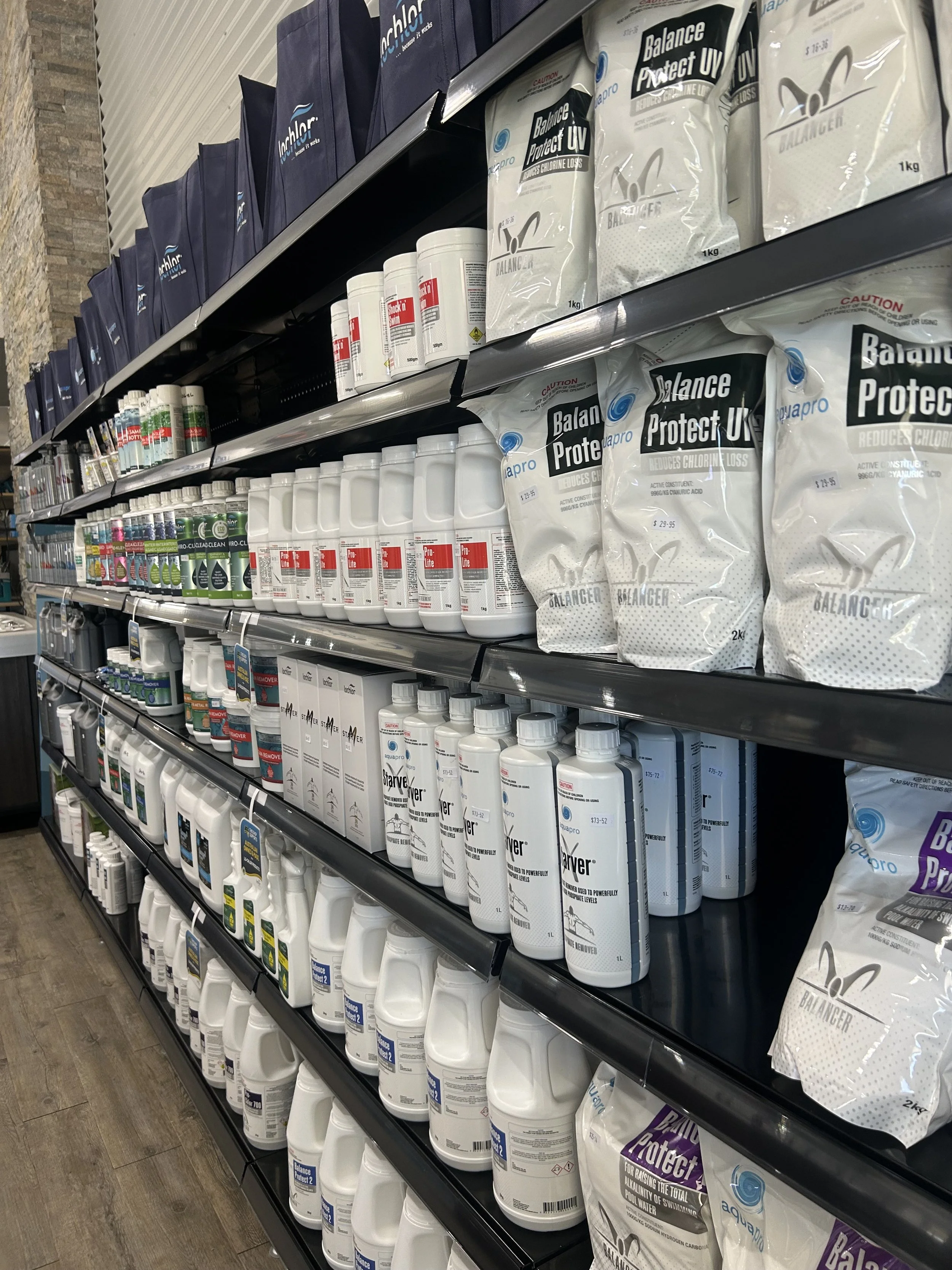 Shelf in a store with various water balancing and detox products, including bottles and bags of supplements.