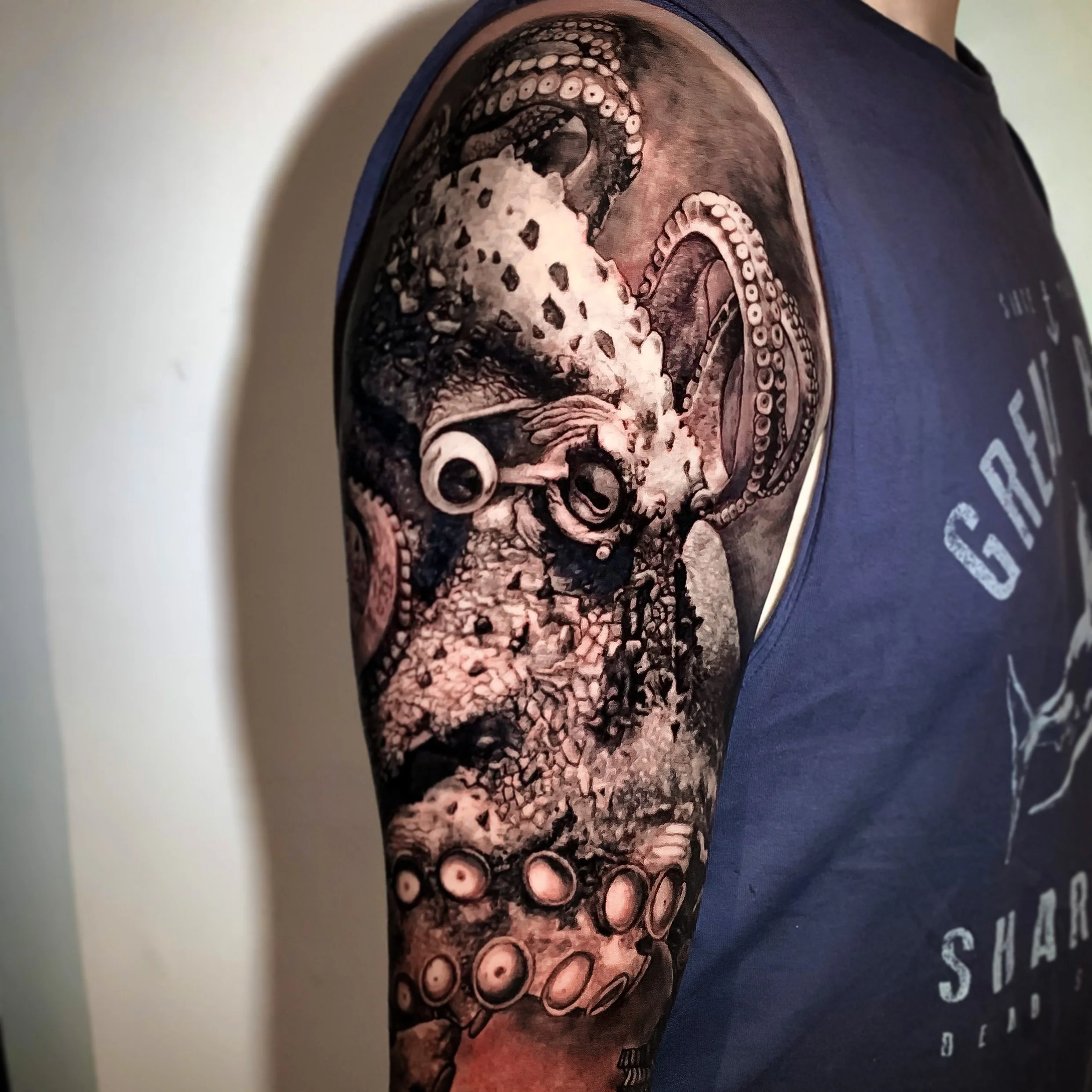 Tattoo of a realistic octopus with detailed tentacles on a person's upper arm.