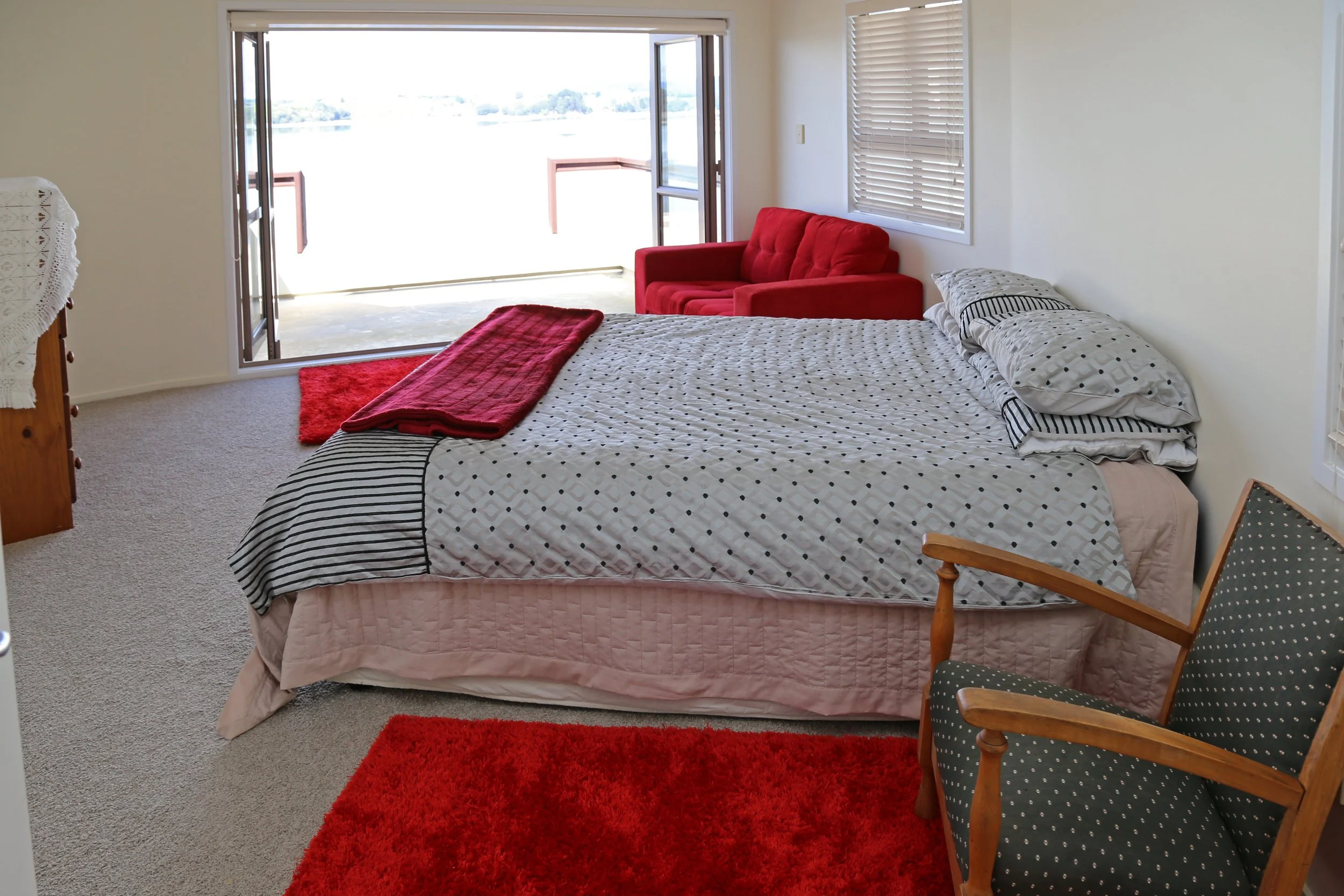 upstairs queen bdroom with doors to private balcony with harbour views