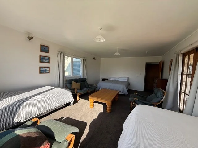 big downsstairs bedroom with lounge chairs