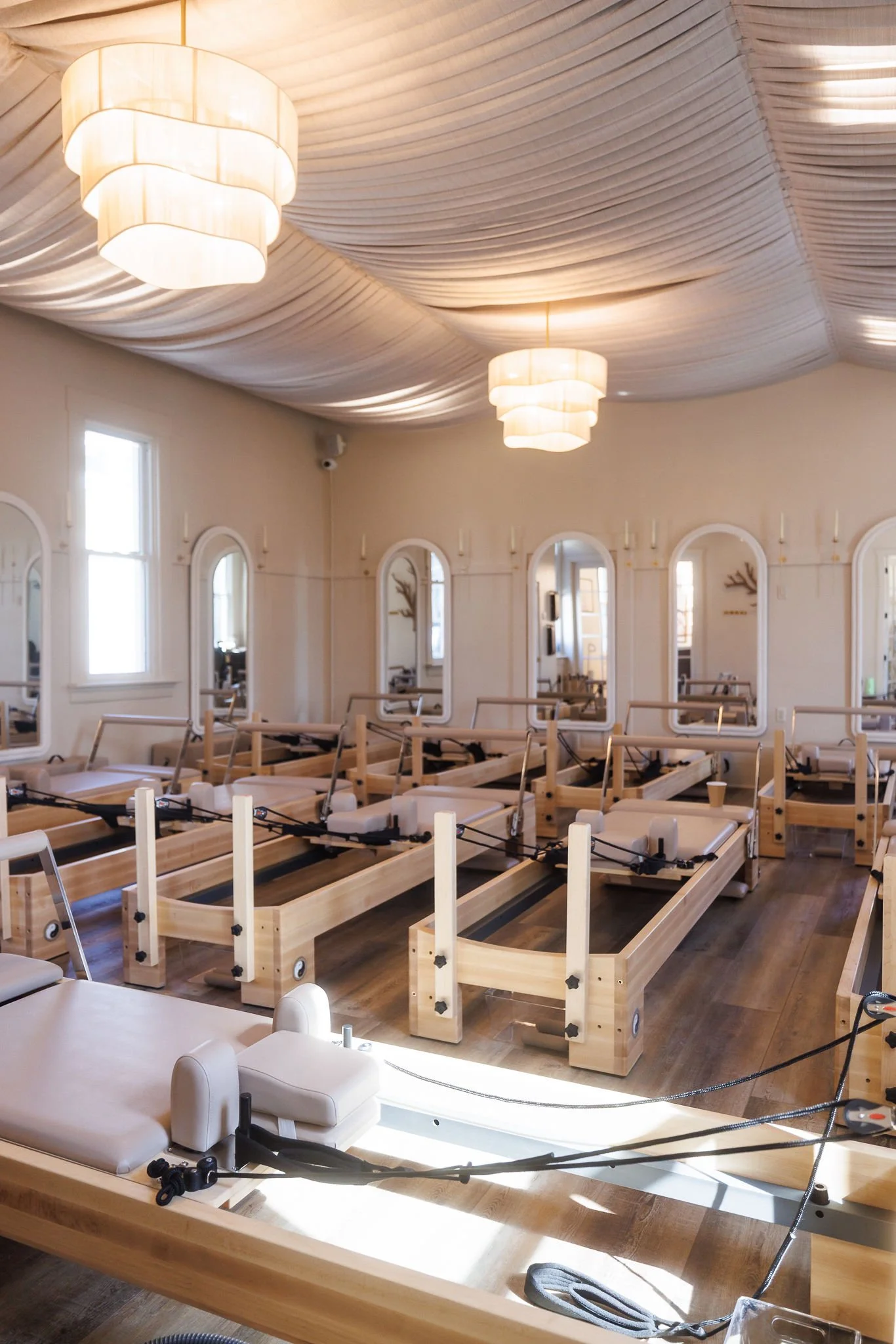 Reformer Pilates studio with wooden reformers, mirrors, and natural light