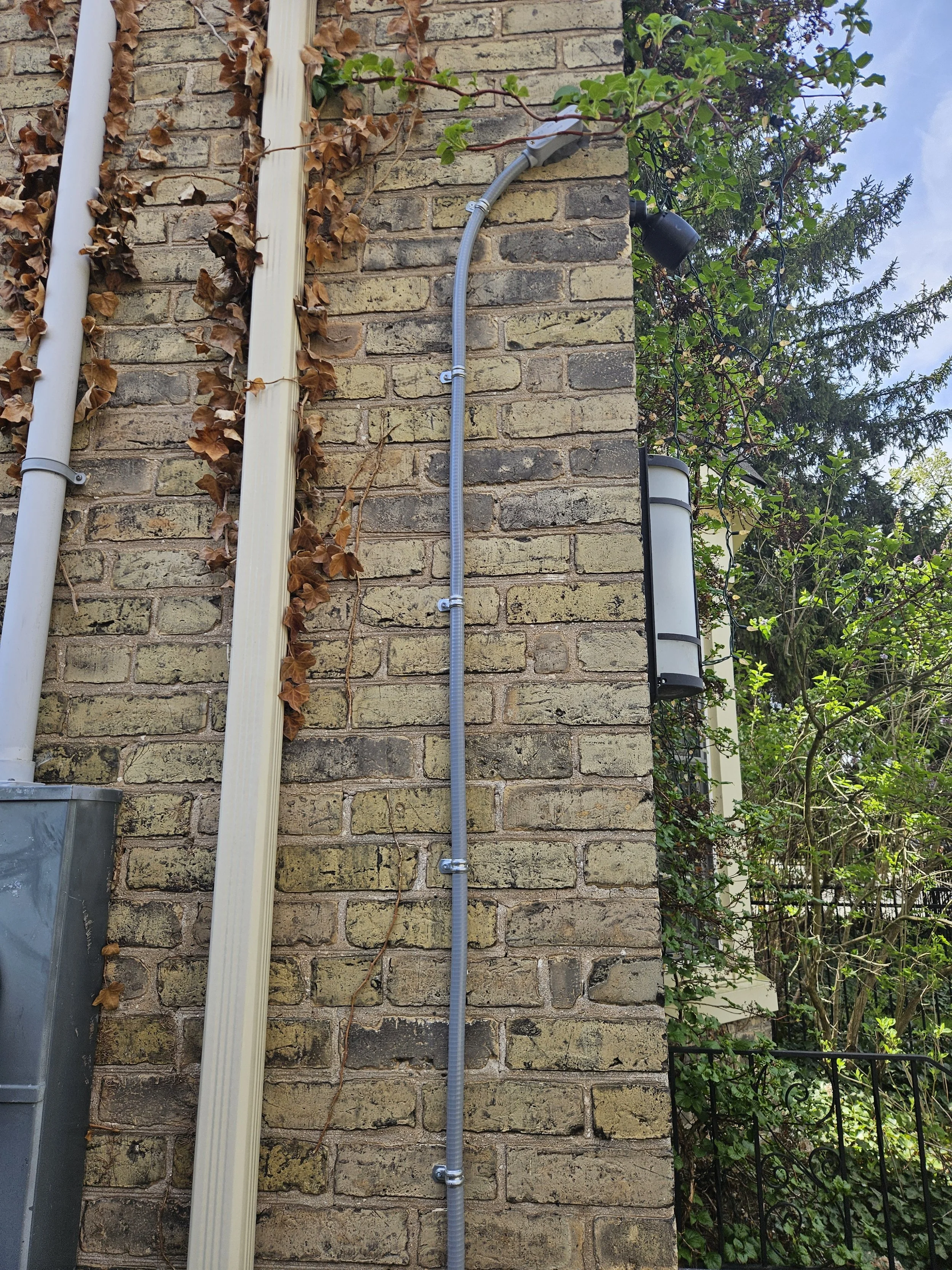 liquid tight conduit on brick wall with black unifi G6 Bullet Camera