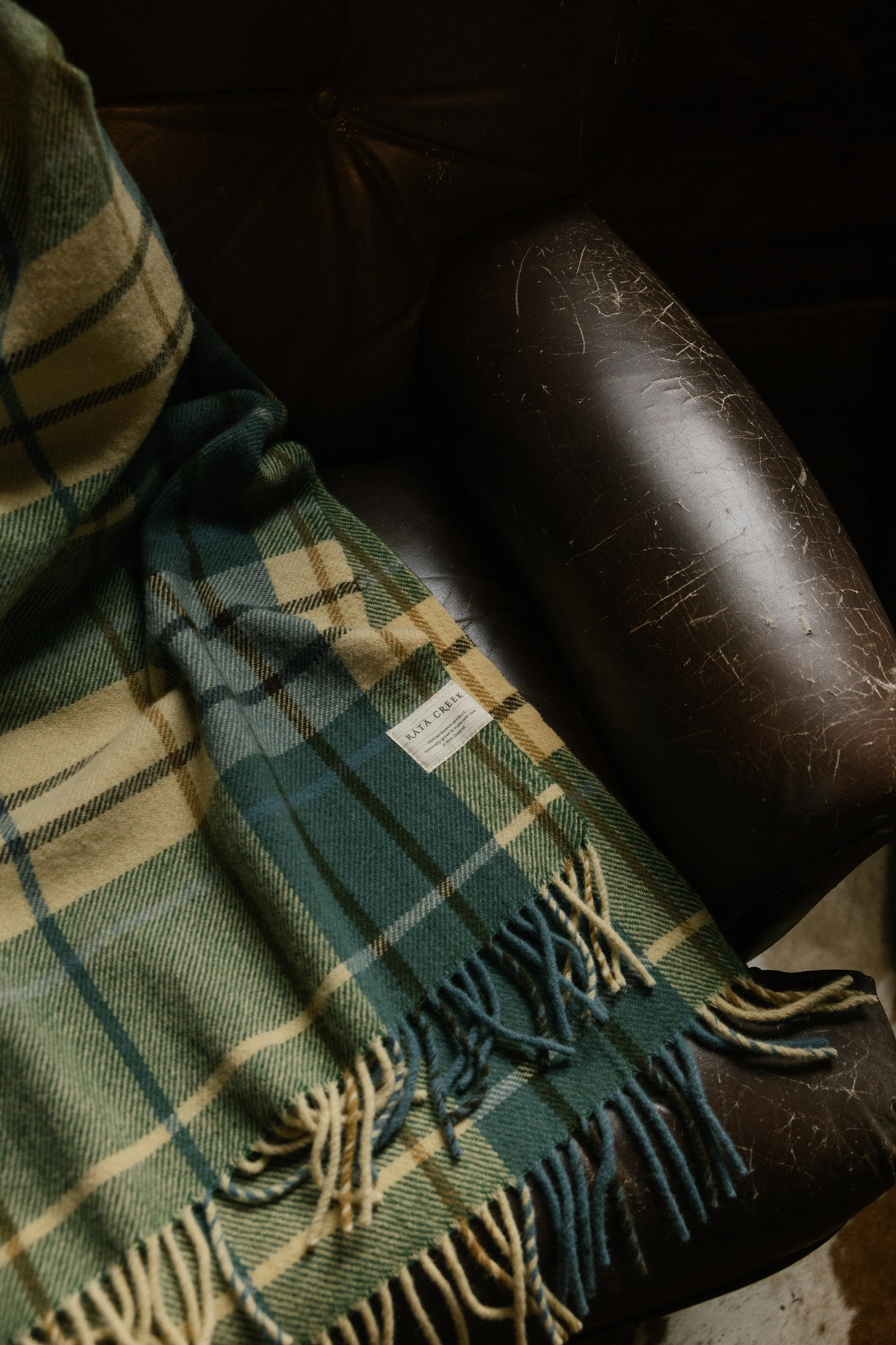 Rātā Creek Waikato tartan on brown leather chair.jpg