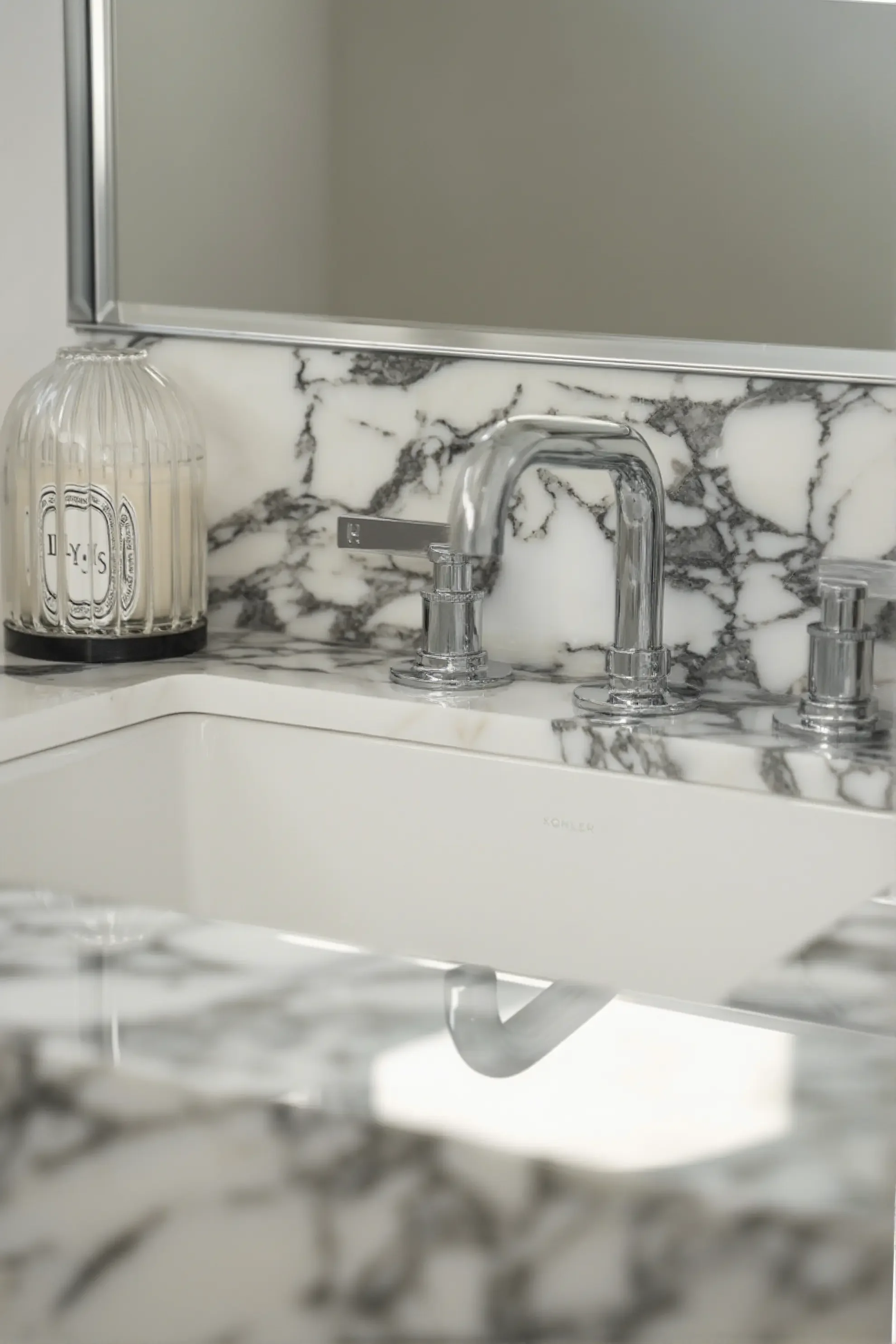 Luxury powder room in Toronto designed by Claire Design Studio, featuring a bespoke thick-edge marble vanity with dramatic veining, modern minimalist pendant lighting, and a custom wood cabinet.