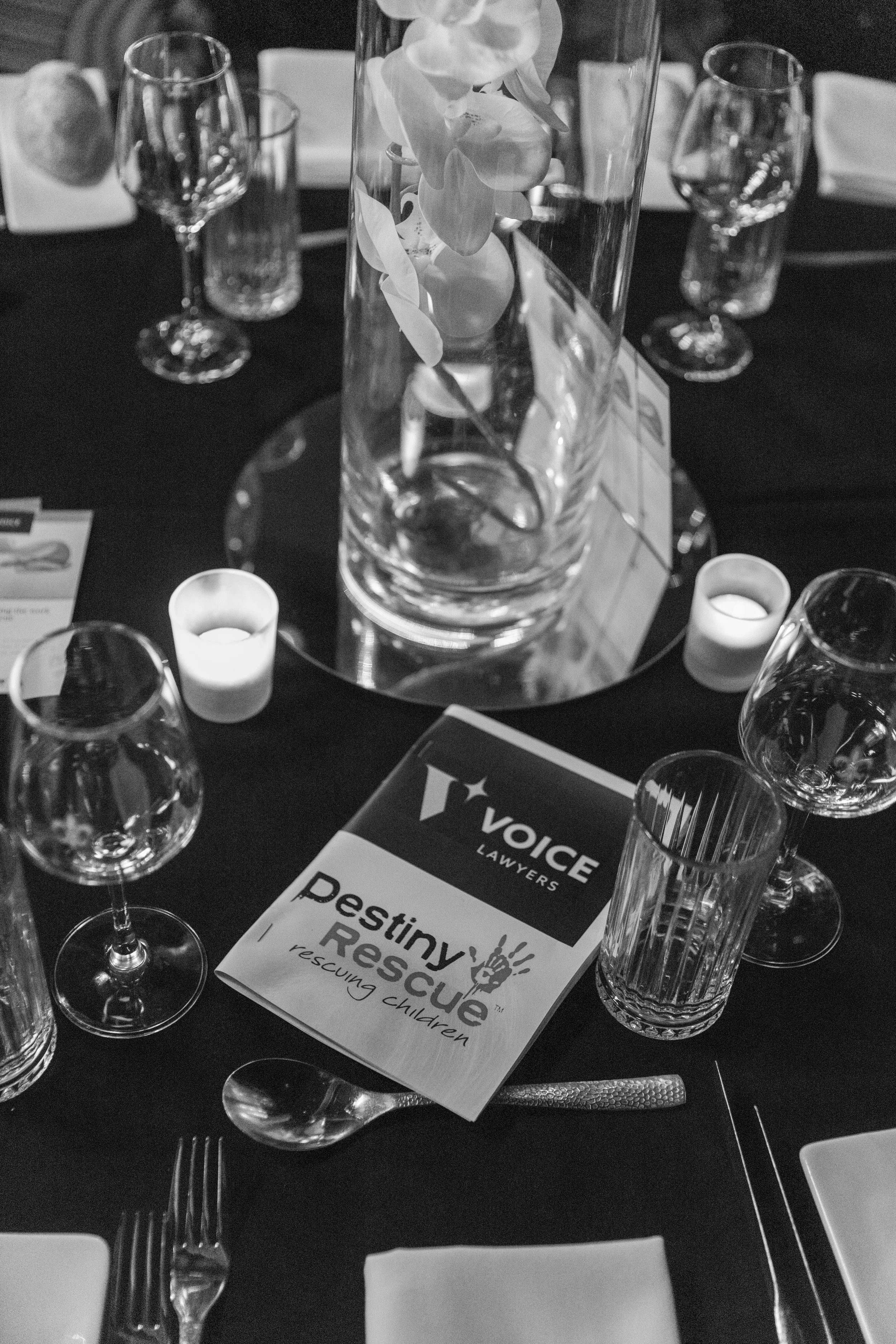 Table setup with Destiny Rescue brochure and glassware.